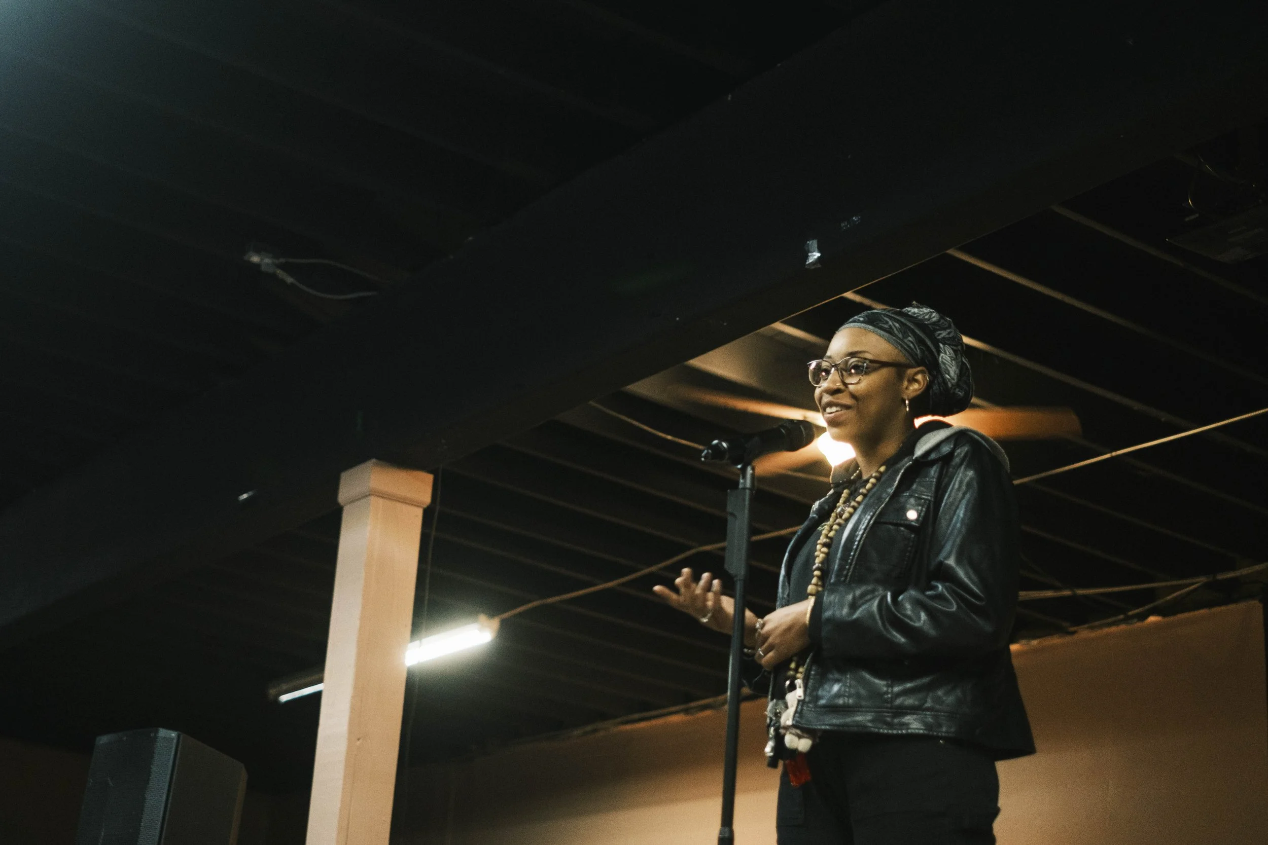 A poet speaks on stage during an open mic poetry slam in Detroit at Artist Village