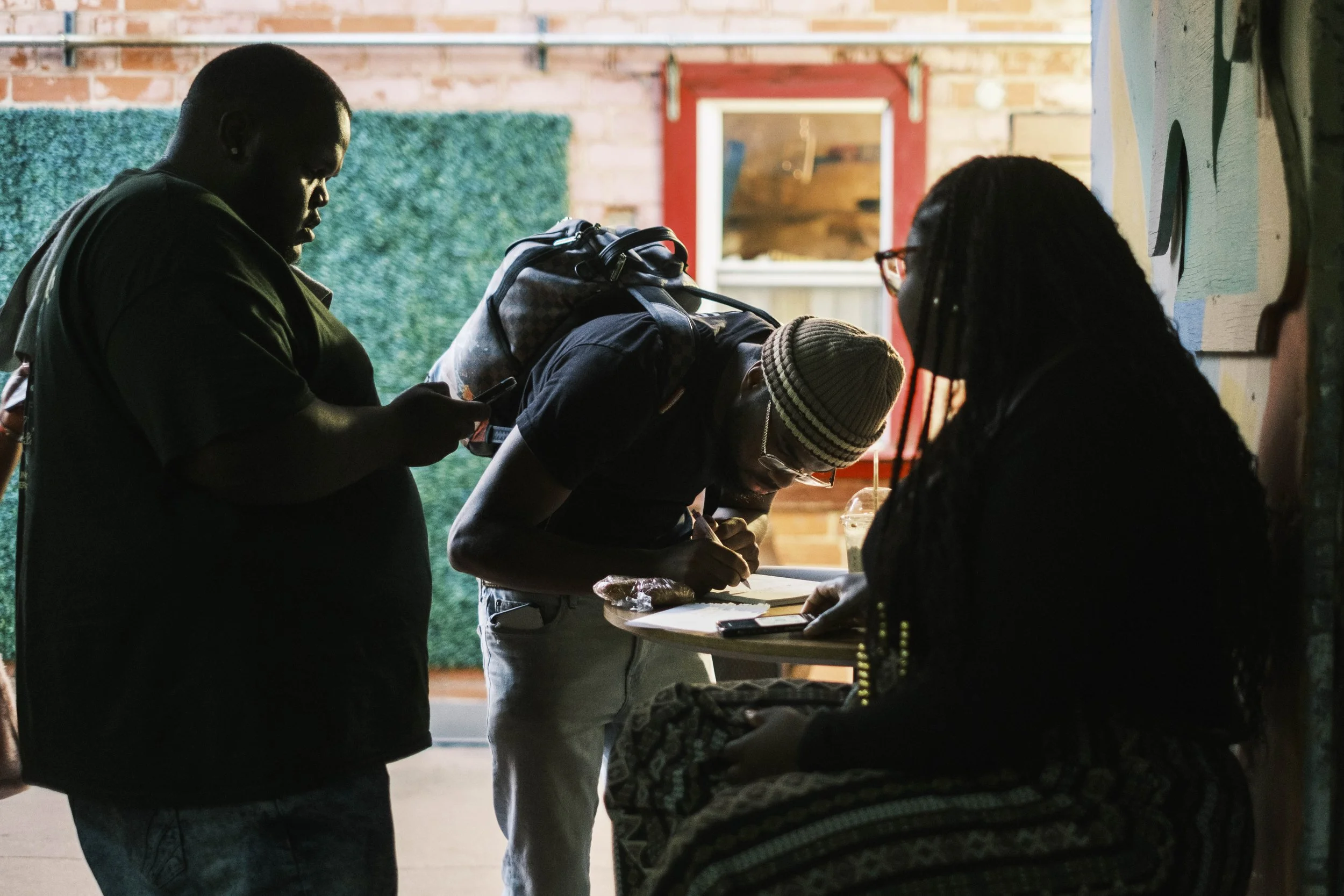 A person signs up for an open Mic poetry event at Artist Village in Detroit