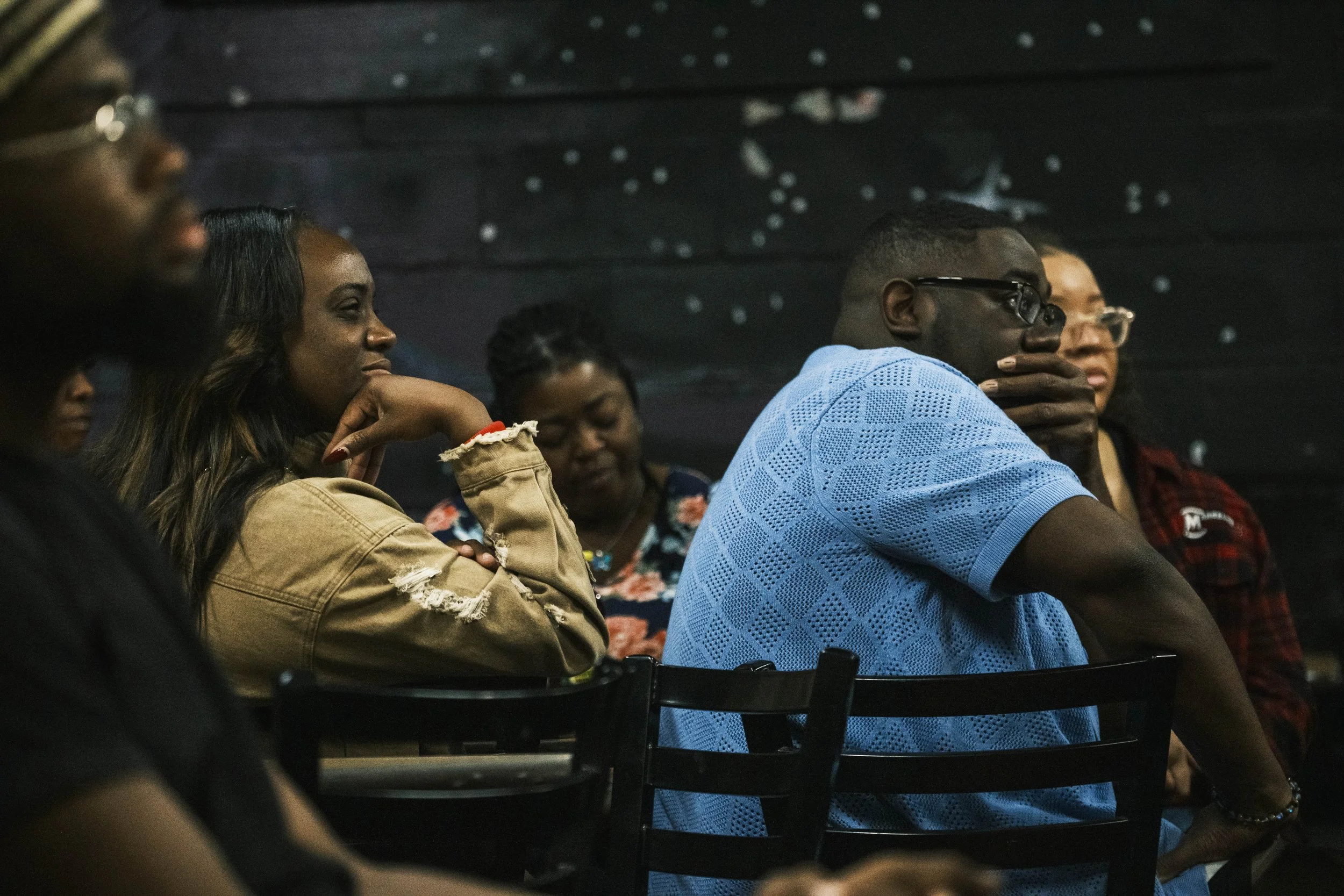 The audience listens to a poet on stage during an Open Mic poetry slam event at Artist Village in Detroit