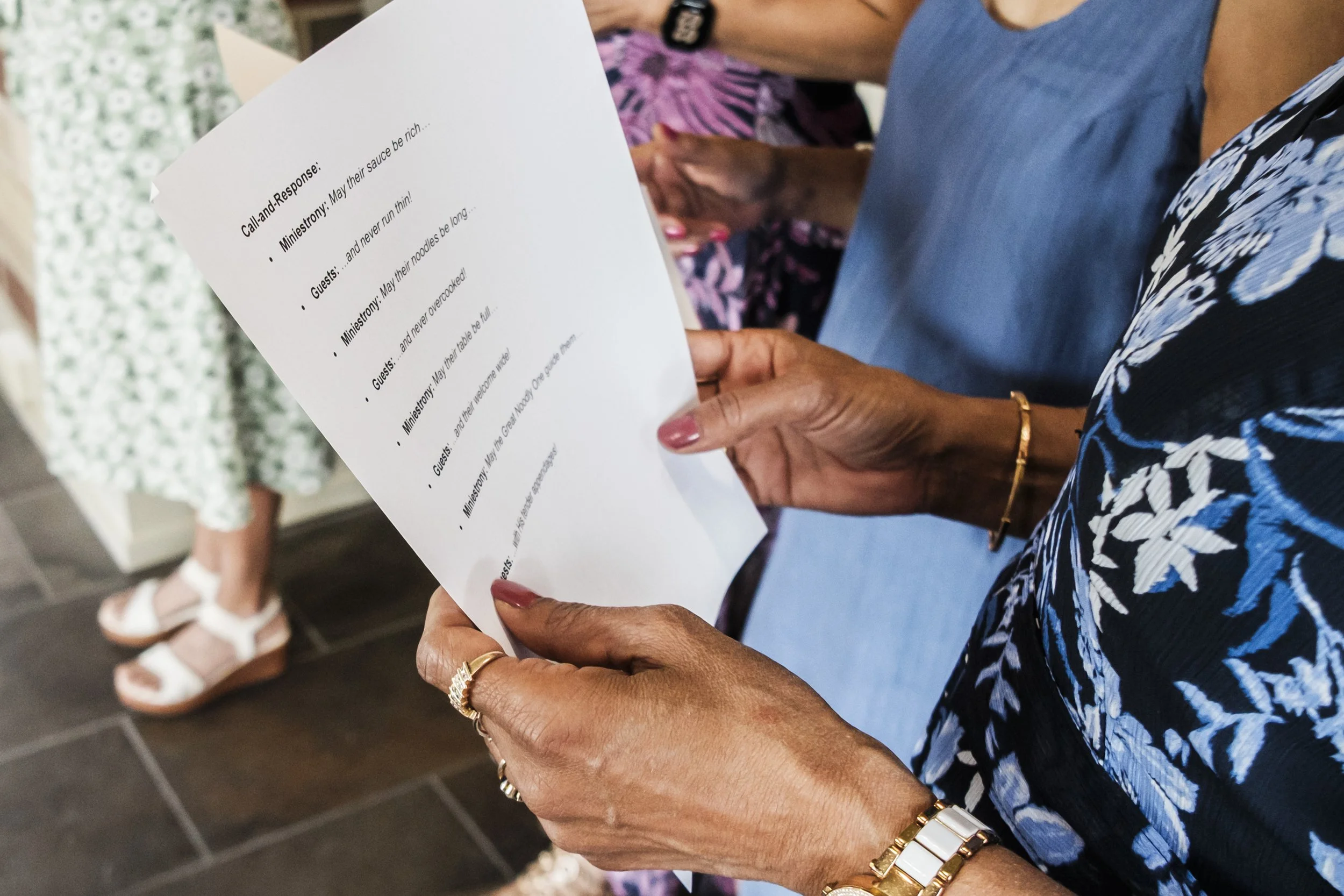 Hands hold a paper that lists calls and responses for an intimate wedding.