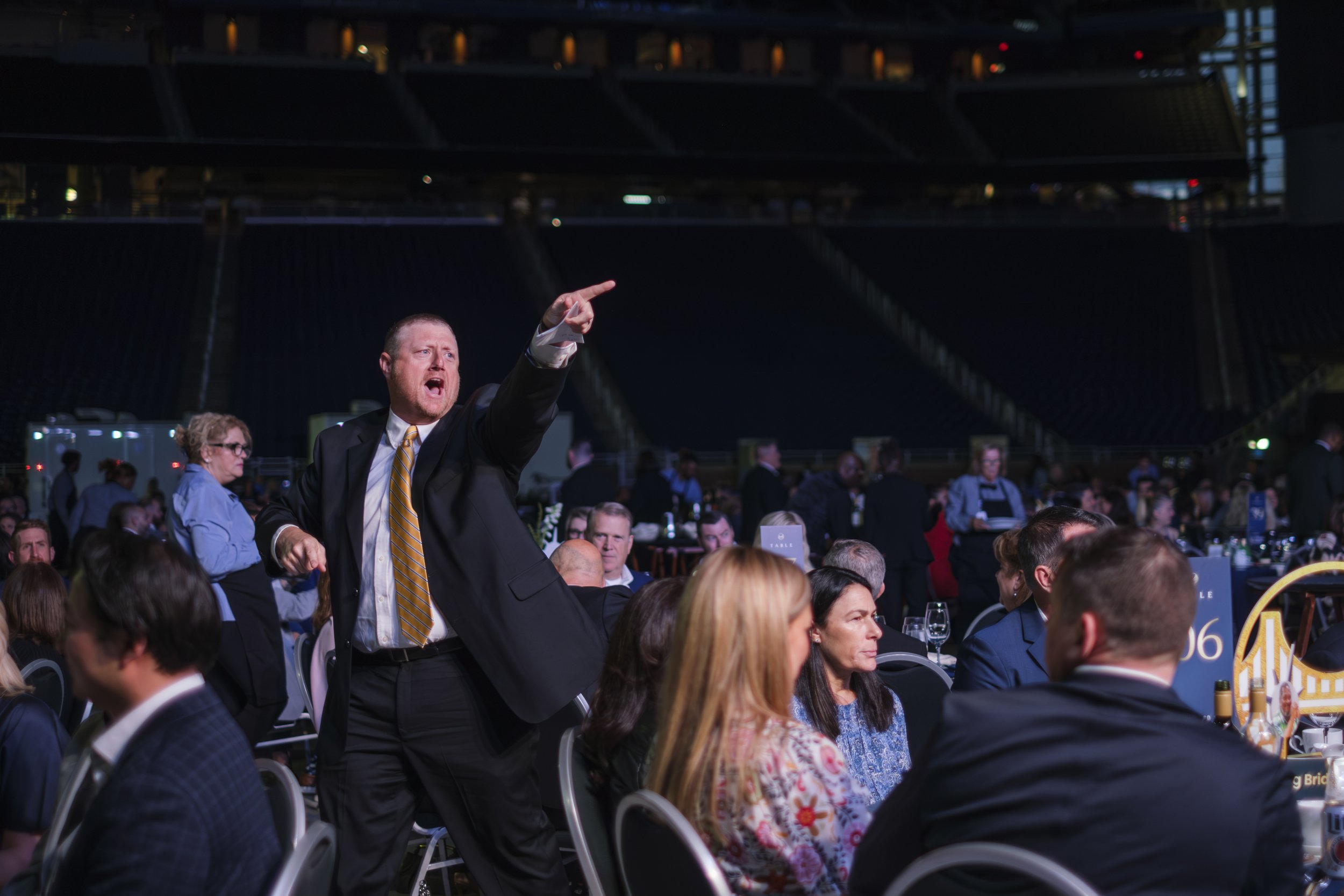 A man wearing a suit yells and points during the auction portion of the non profit Pope Francis Gala Building Bridges Event in Detroit.