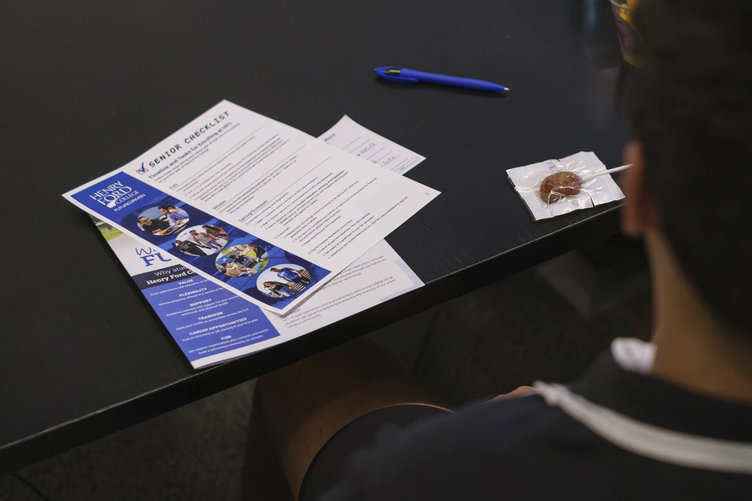 A document that reads "senior checklist" sits on a table on top of another brochure and a pen.