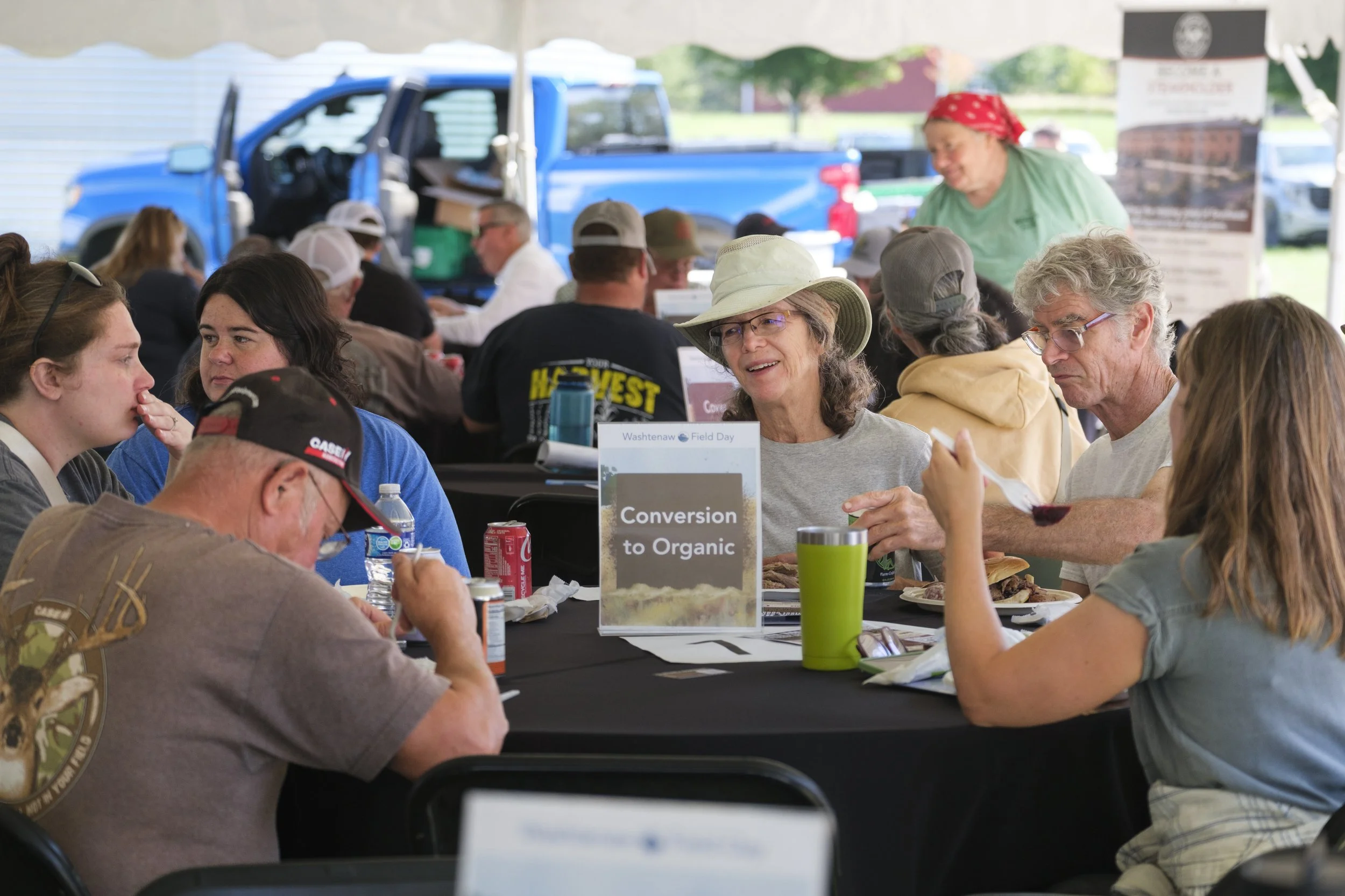 A group of farmers and gardeners sit around a table during the break session at the Washtenaw County Conservation District's Farmer Field Day.