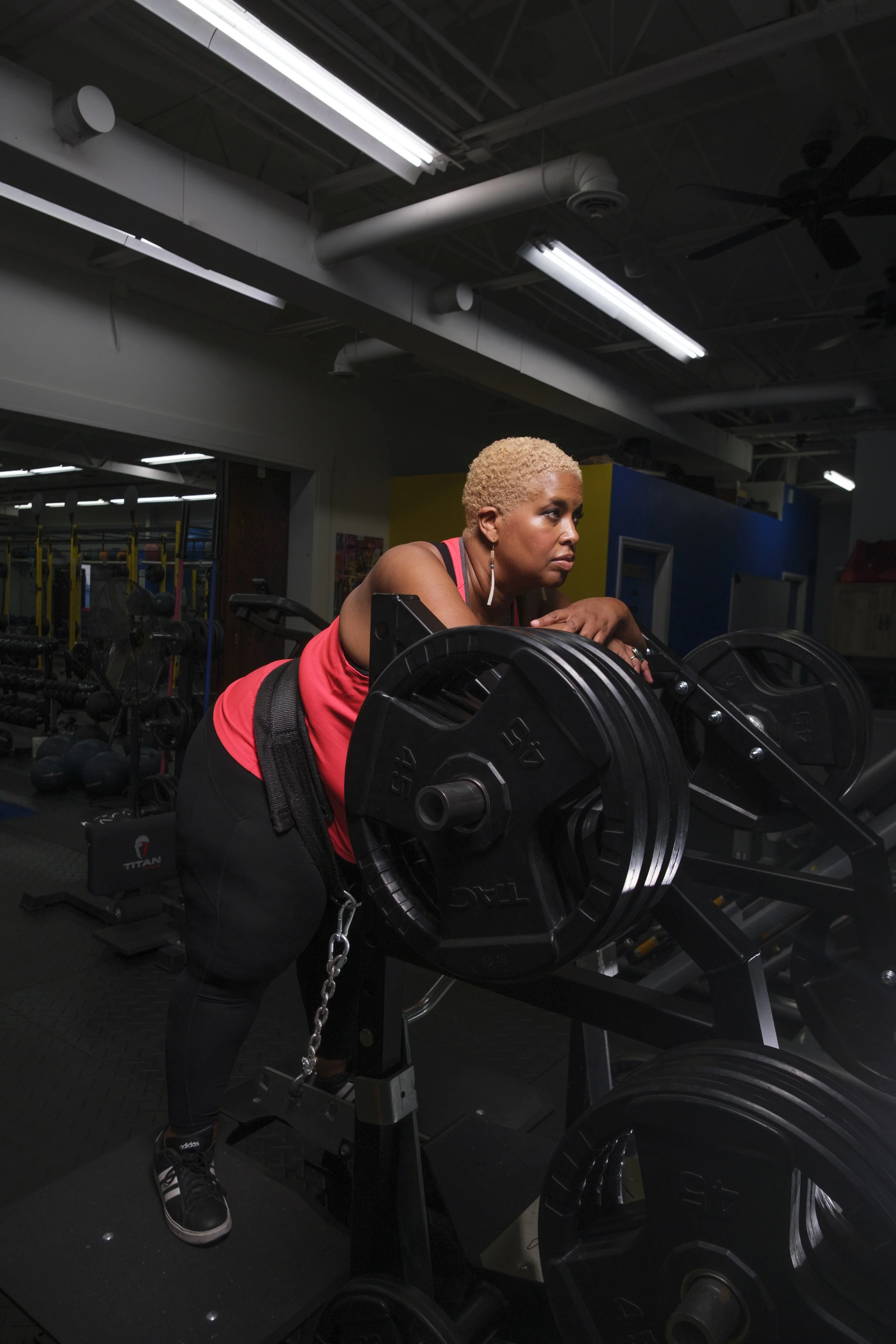 A women intensely stares forward while using a weight lifting machine.