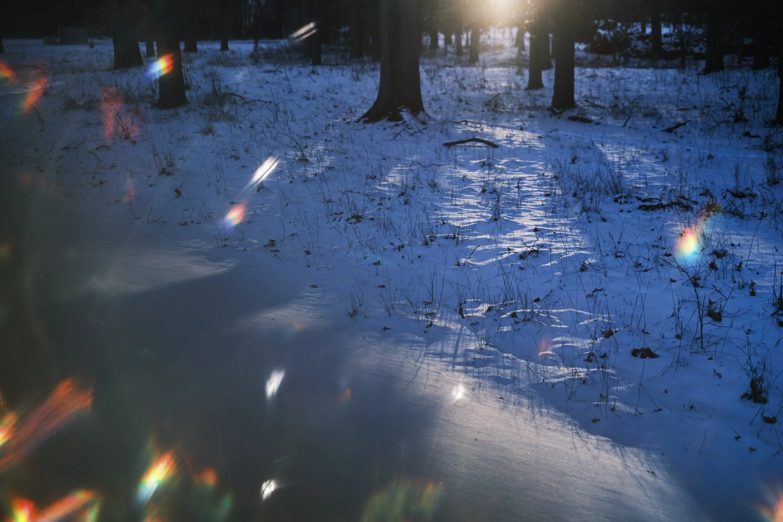 A sunset is cast on snow with rainbows