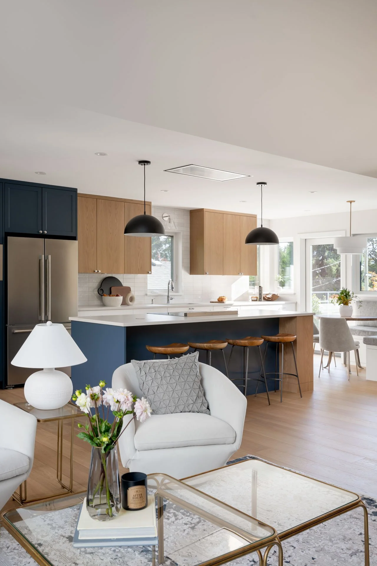 Interior photography of modern open-concept kitchen adjacent to a cozy living area, designer Triple Dot Design Studio