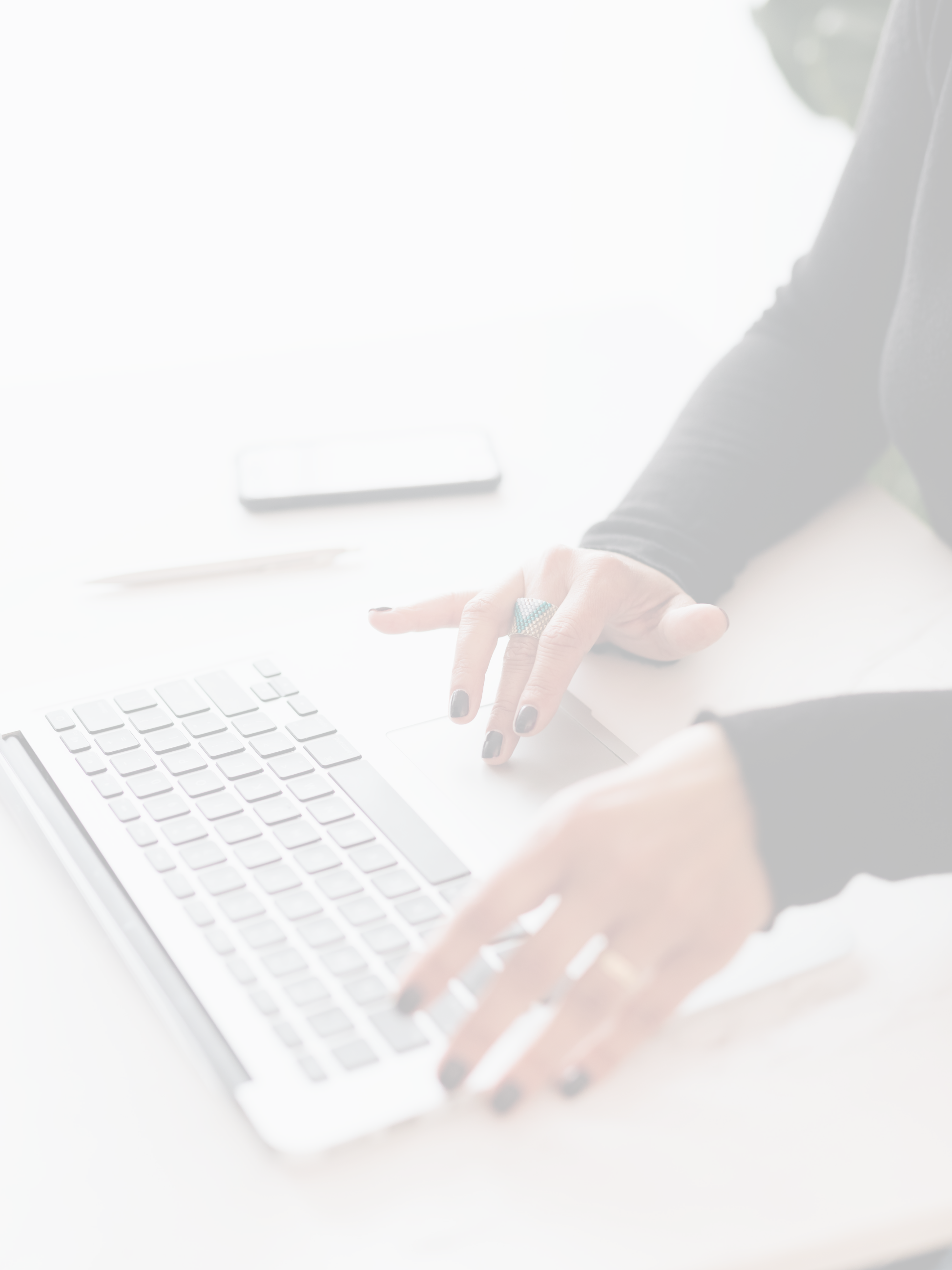 A faded image of a woman's hands typing on a laptop