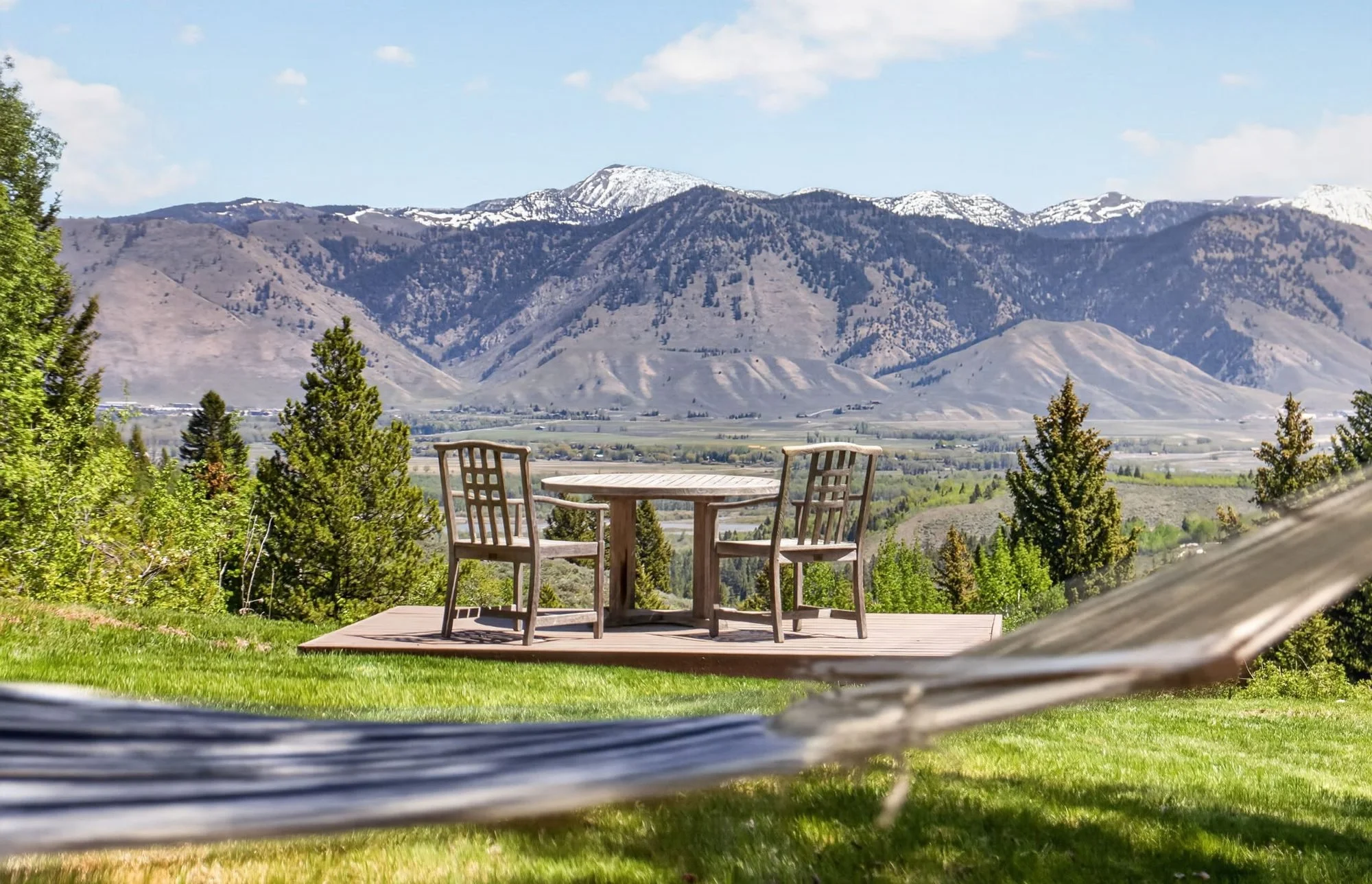 View from a hammock over a picnic deck toward the mountains at Hidden Hills, Wilson, Wyoming