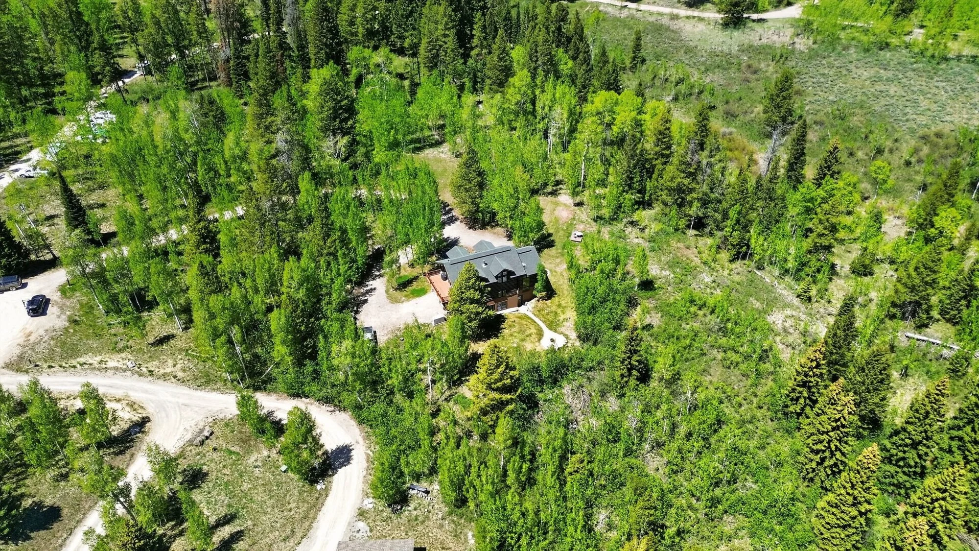 Aerial view of the 7.24-acre Hidden Hills property surrounded by forest south of Wilson, Wyoming