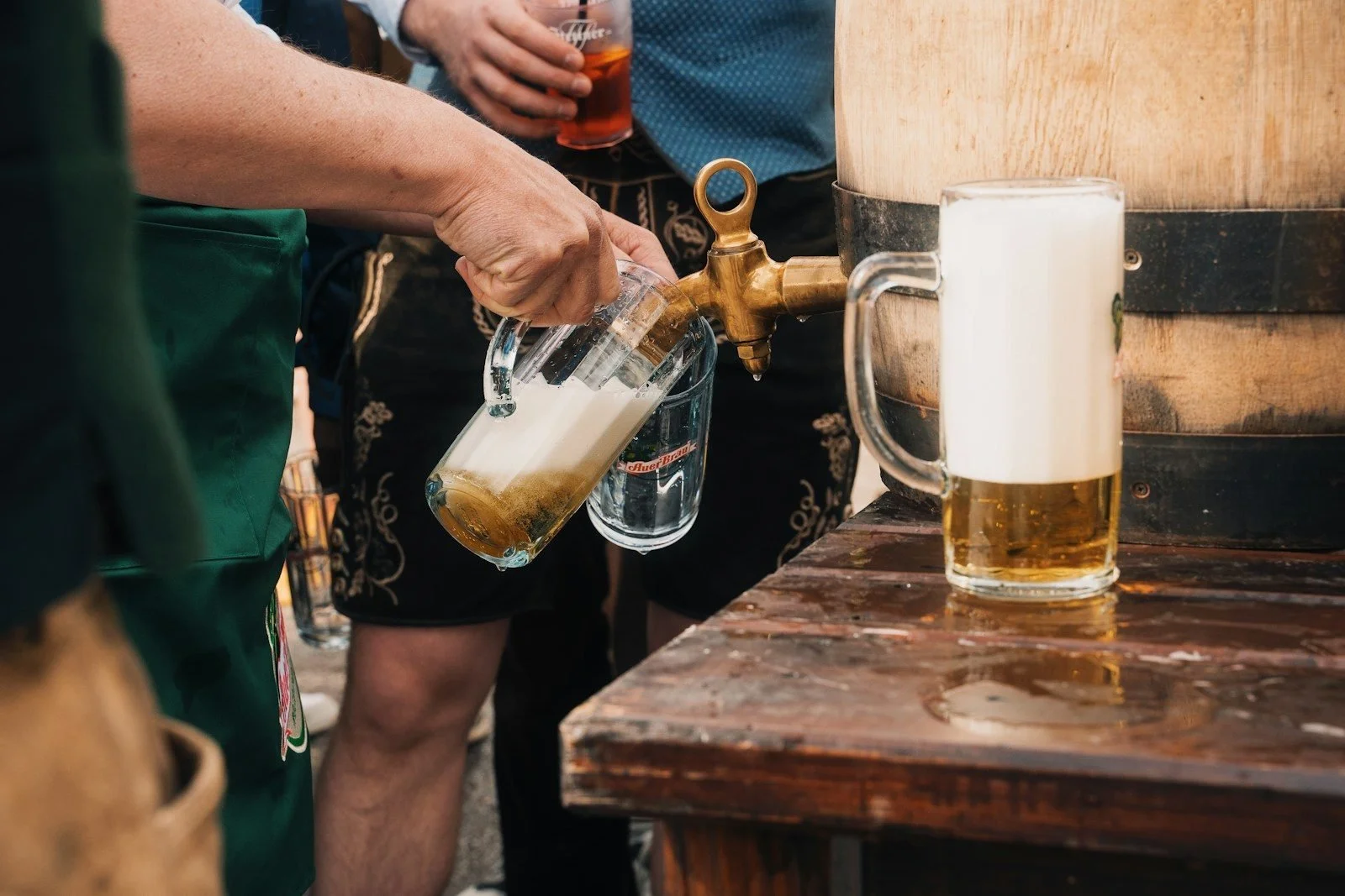 Beer poured from a wooden barrel into a stein at an Oktoberfest celebration