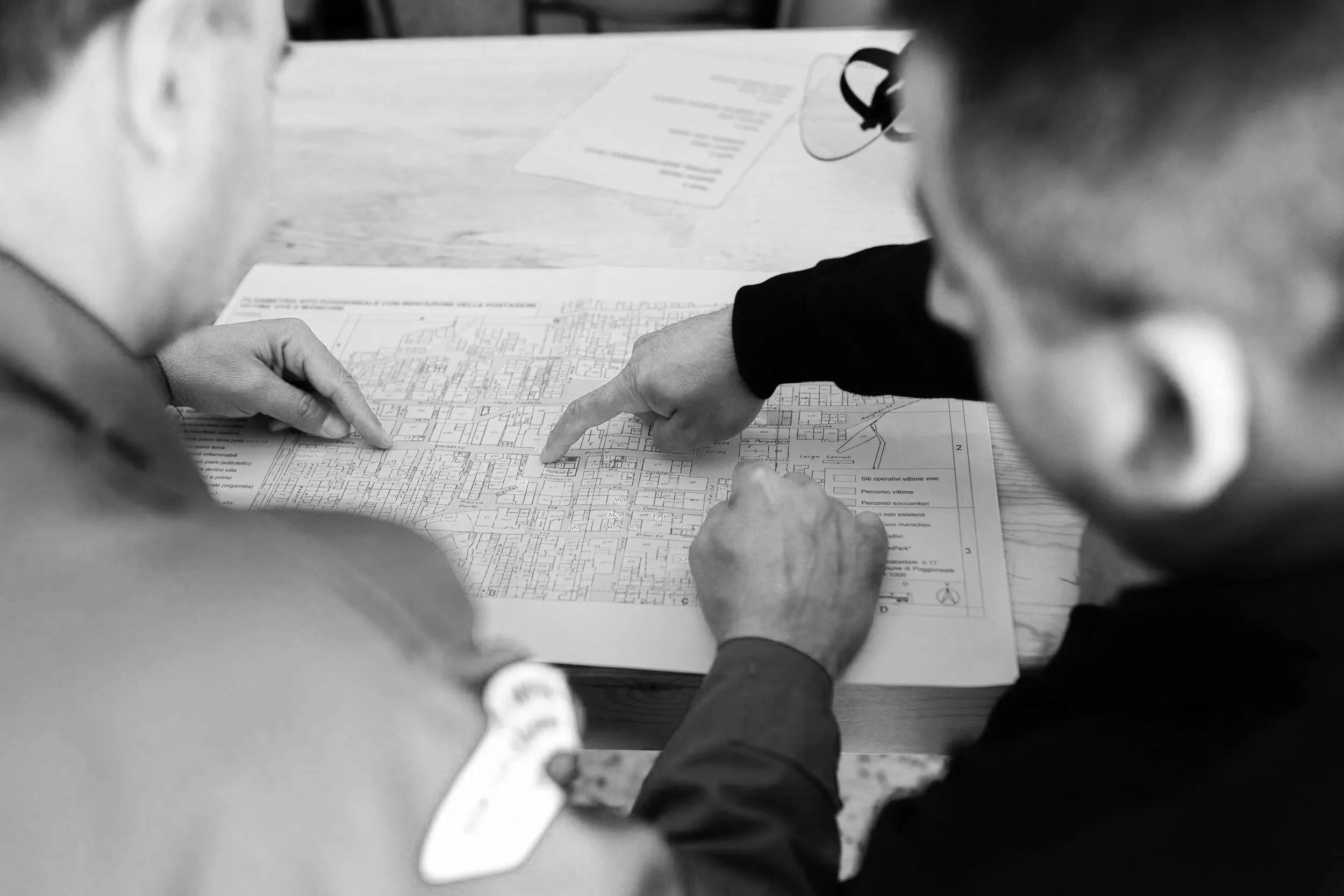 Two people reviewing a detailed community map at a table, pointing at specific BMP and stormwater locations.