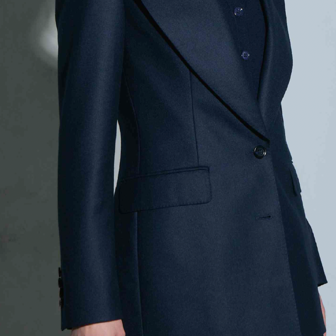 Women's Tailored custom made  Close-up of a person wearing a navy blue tailored blazer.