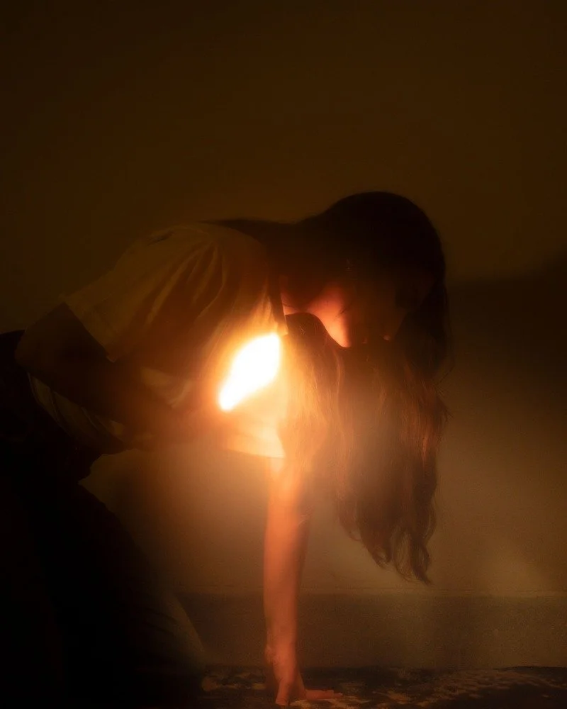 Mujer inclinada con luz brillando desde su interior representando la transformación y el poder de la sanación interior