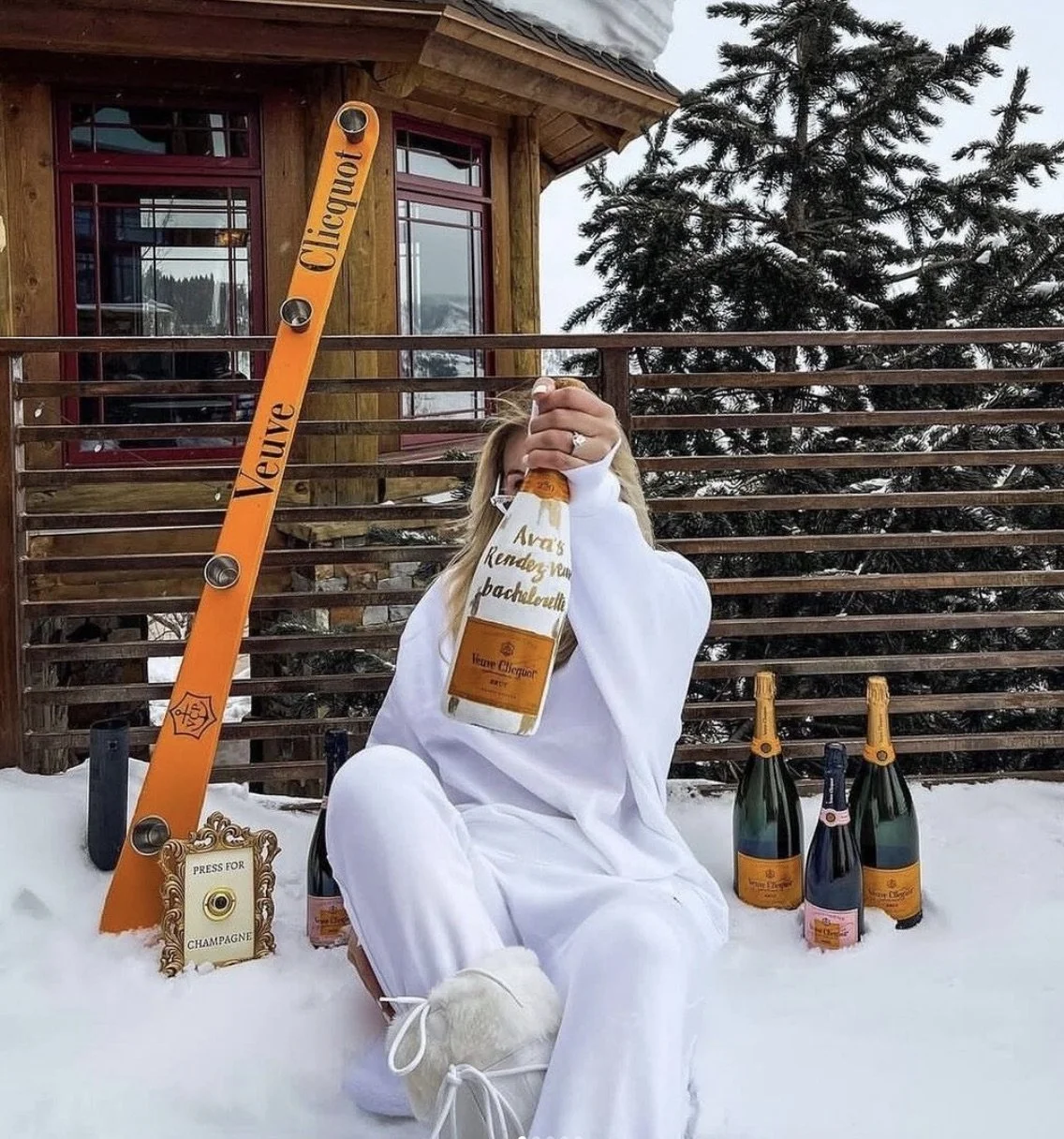 Woman in snow with champagne