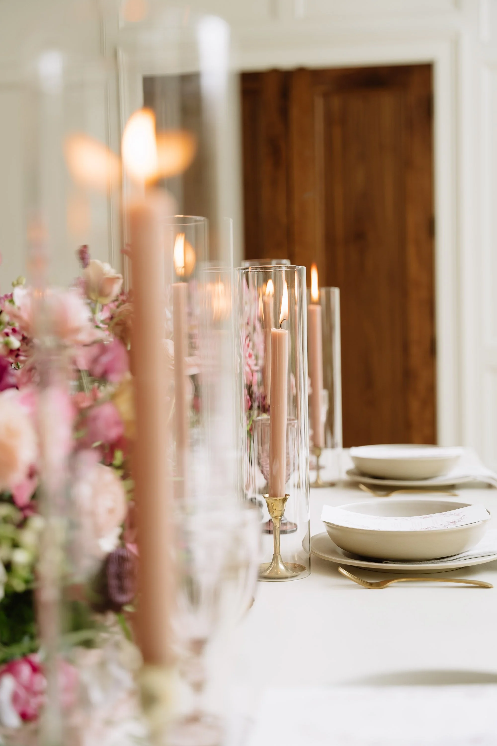 Elegant table setting with pink candles and floral centerpiece in a formal dining room.