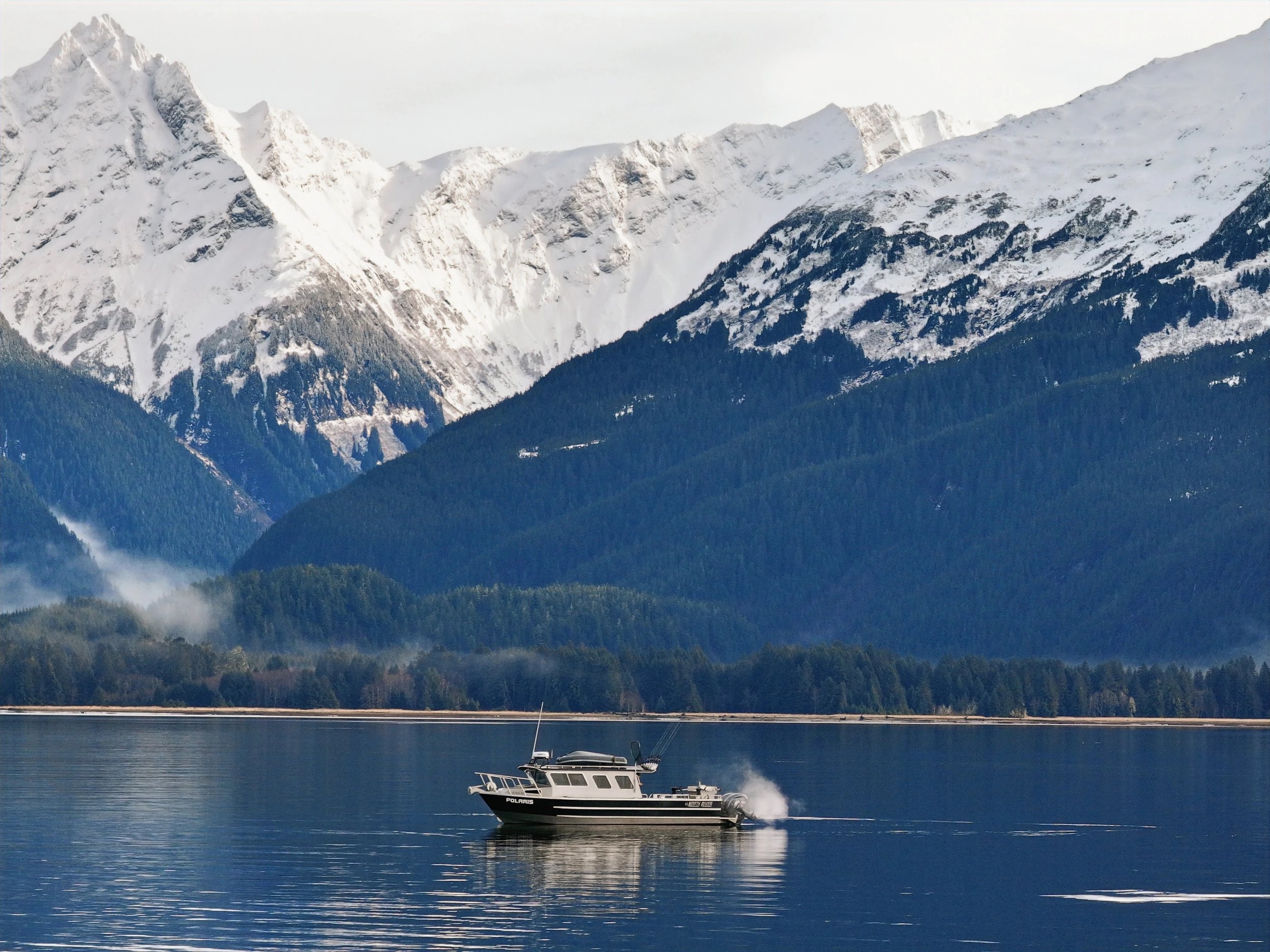 f/v Solaris in Katlian Bay in Sitka Alaska with snowy mountains in the background.