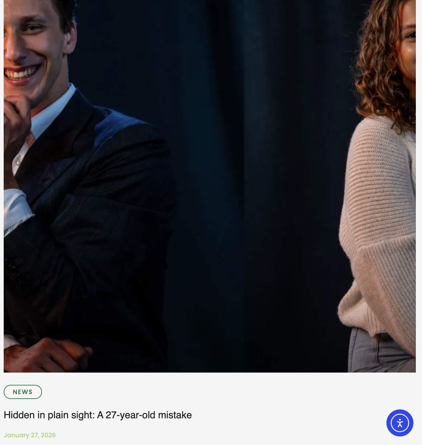 A man and a woman are standing back-to-back, smiling, with the man's face partly visible and the woman's face partially shown. The man is wearing a dark suit and white shirt, and the woman is wearing a beige sweater. The background is dark. The capti