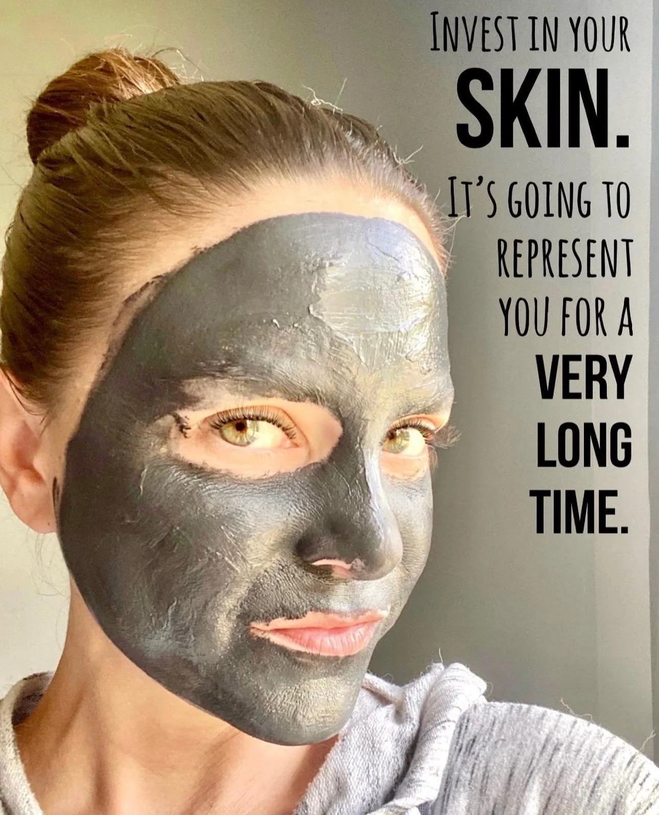 A woman with her hair tied back wearing a metallic facial mask and a gray hoodie. A motivational quote about investing in skin is displayed on the right side of the image.