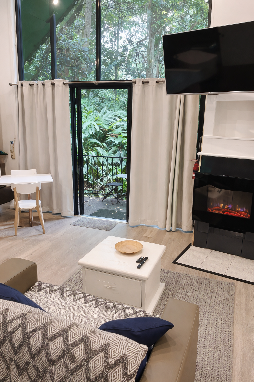 Relax in a cosy open-plan living space at Gallery Walk Chalets, where rainforest views, comfortable furnishings and indoor-outdoor flow create the perfect holiday retreat.