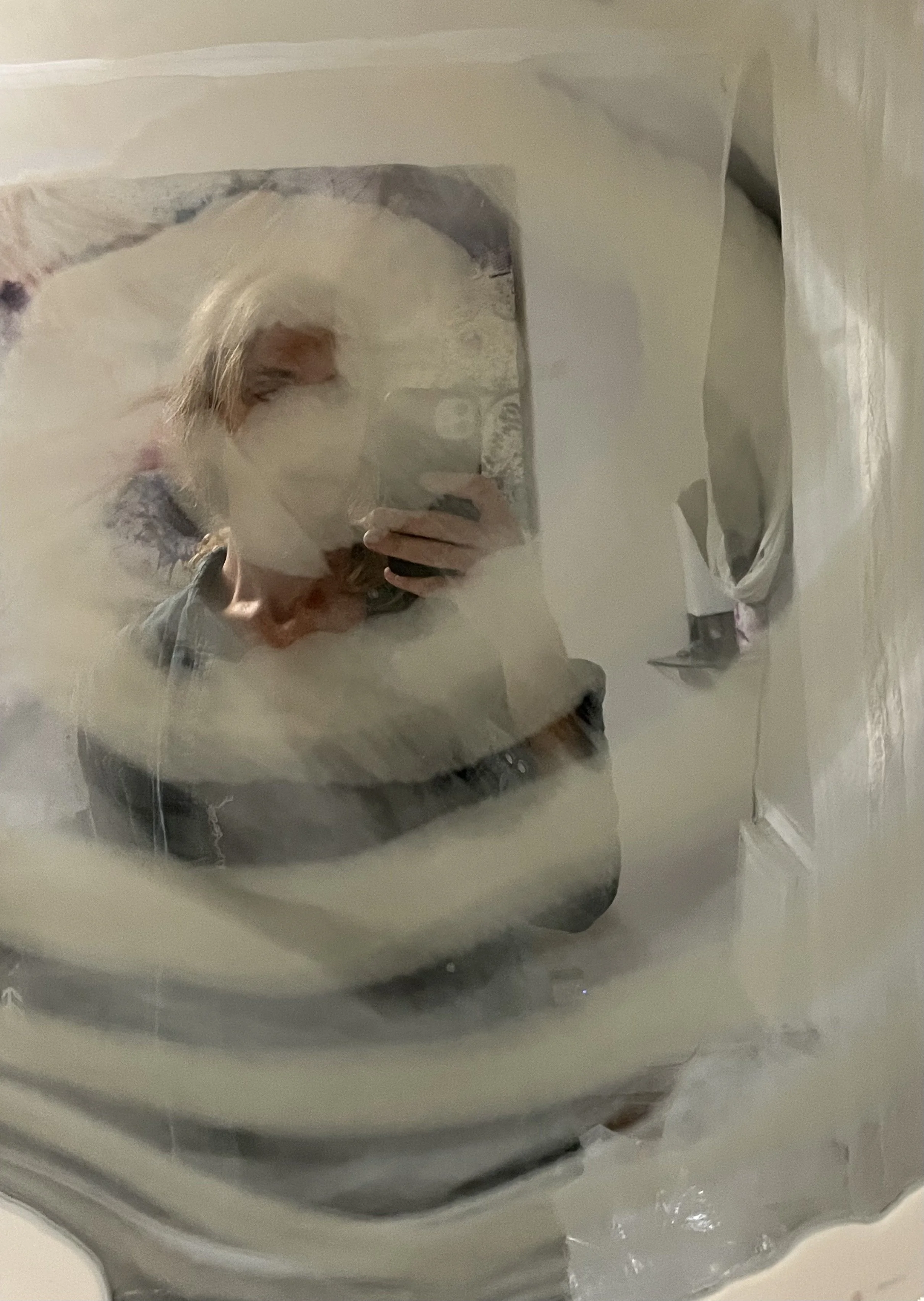 Person taking a photo in a smoky resin mirror.