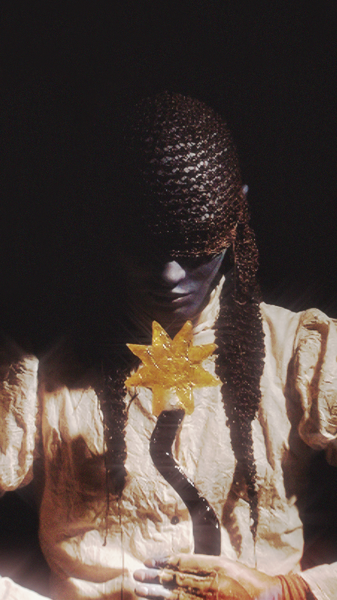 SIM wearing an Auntie Flew hat and holding a wavy purple resin magic wand with a yellow resin sun attached to the top.