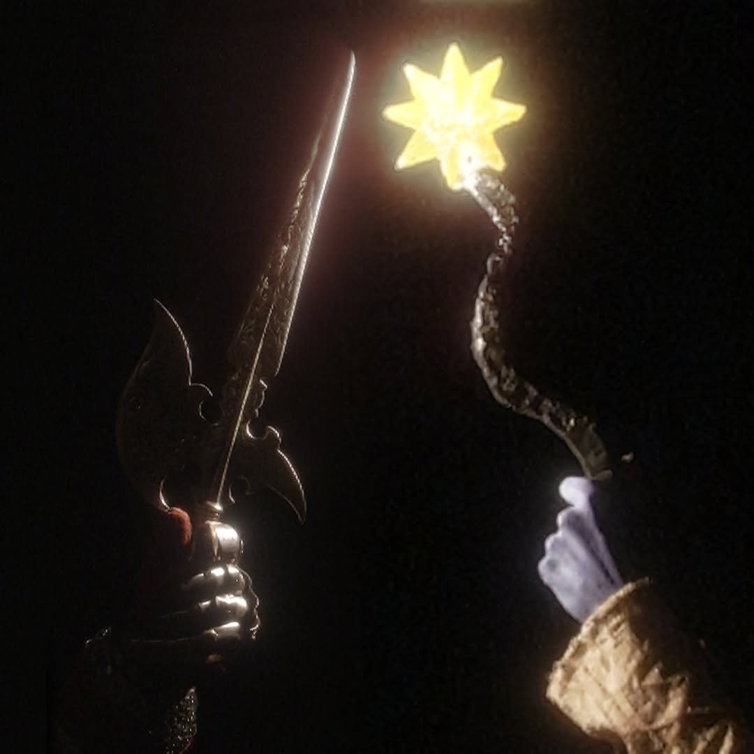 Zaia holding a sword and SIM raising a magic sun wand against a dark sky.
