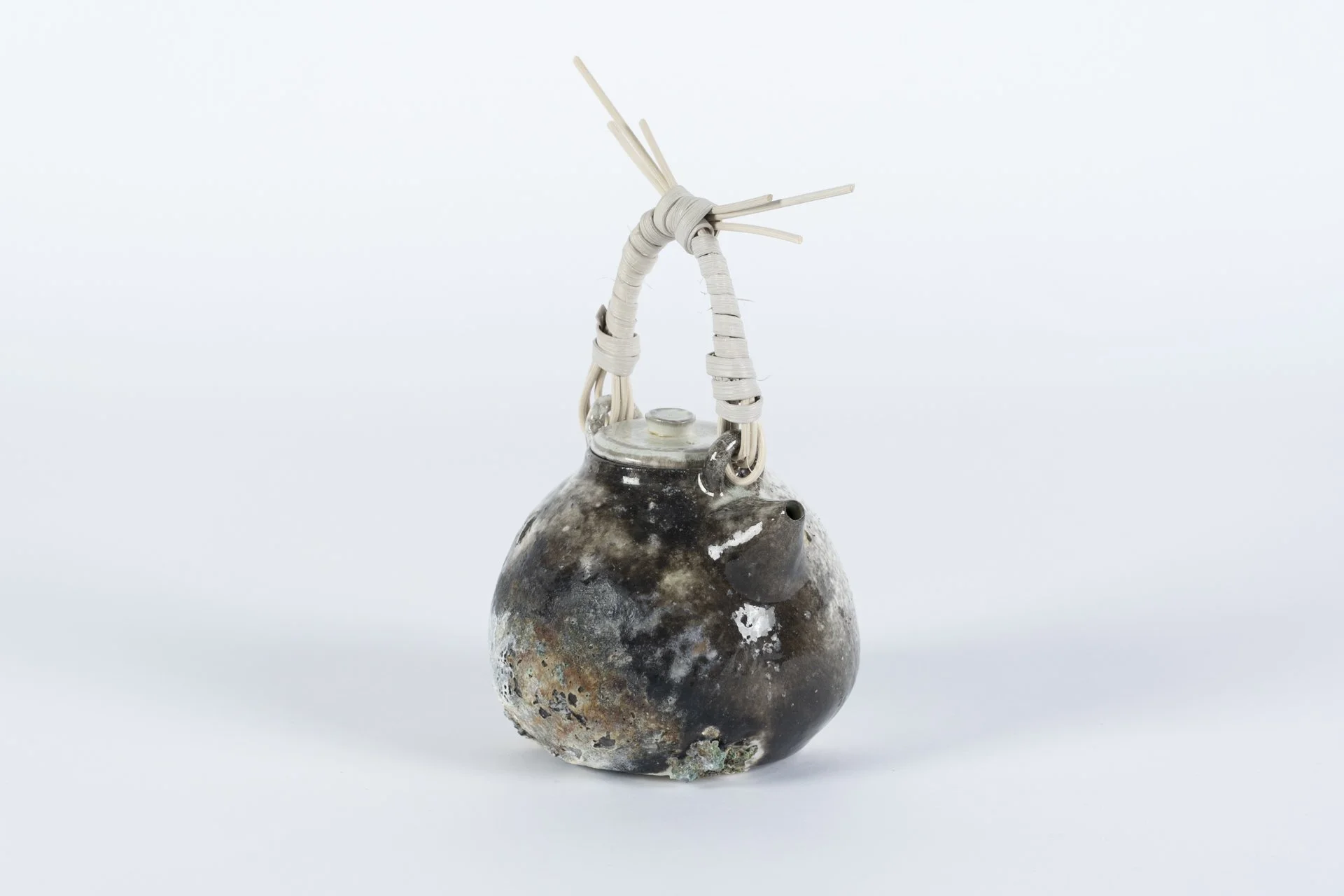 Crusty Pot Teapot with Cane Handle, 2025, Porcelain, Reeds. Fast-Fired, using gas, soda ash,
wood, and wood ash 9 x 8 x 4 ½ in.