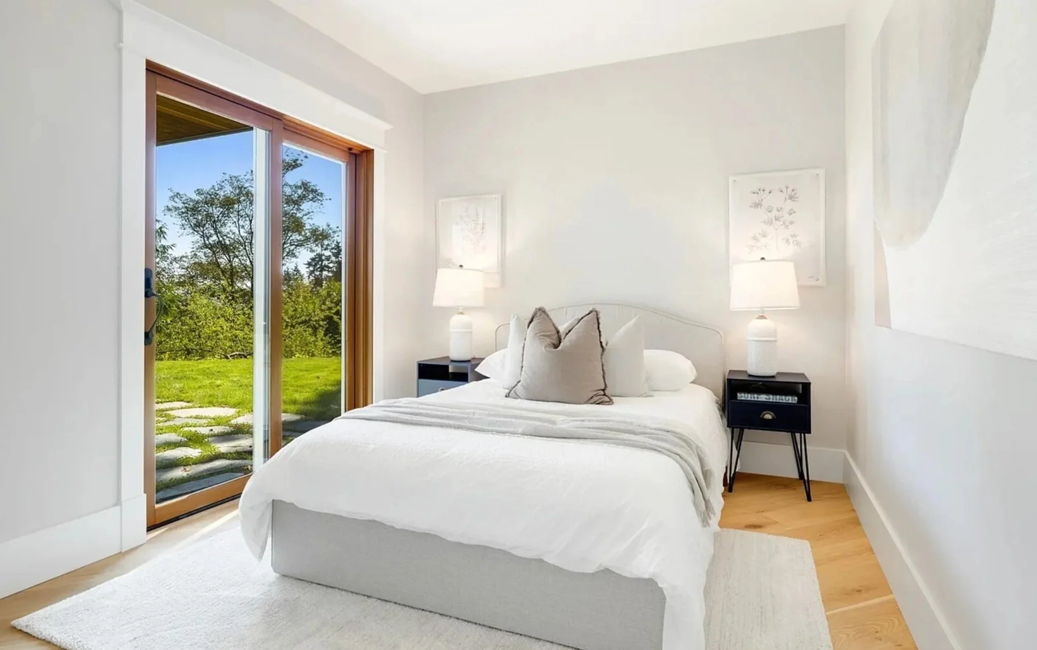An image of a newly finished basement bedroom leading to an English style flagstone patio.