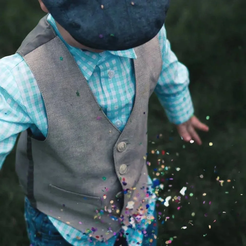 Fine art candid of boy enjoy the wedding throwing confetti to the ground