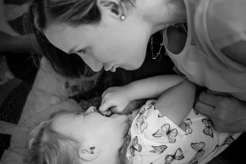 Mother and Daughter enjoying each other on a quilt