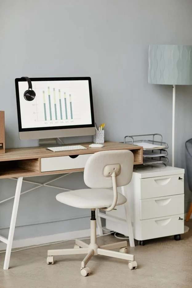 Clean and organized home office workspace with desk, computer, and minimal supplies, creating a focused and clutter-free environment.