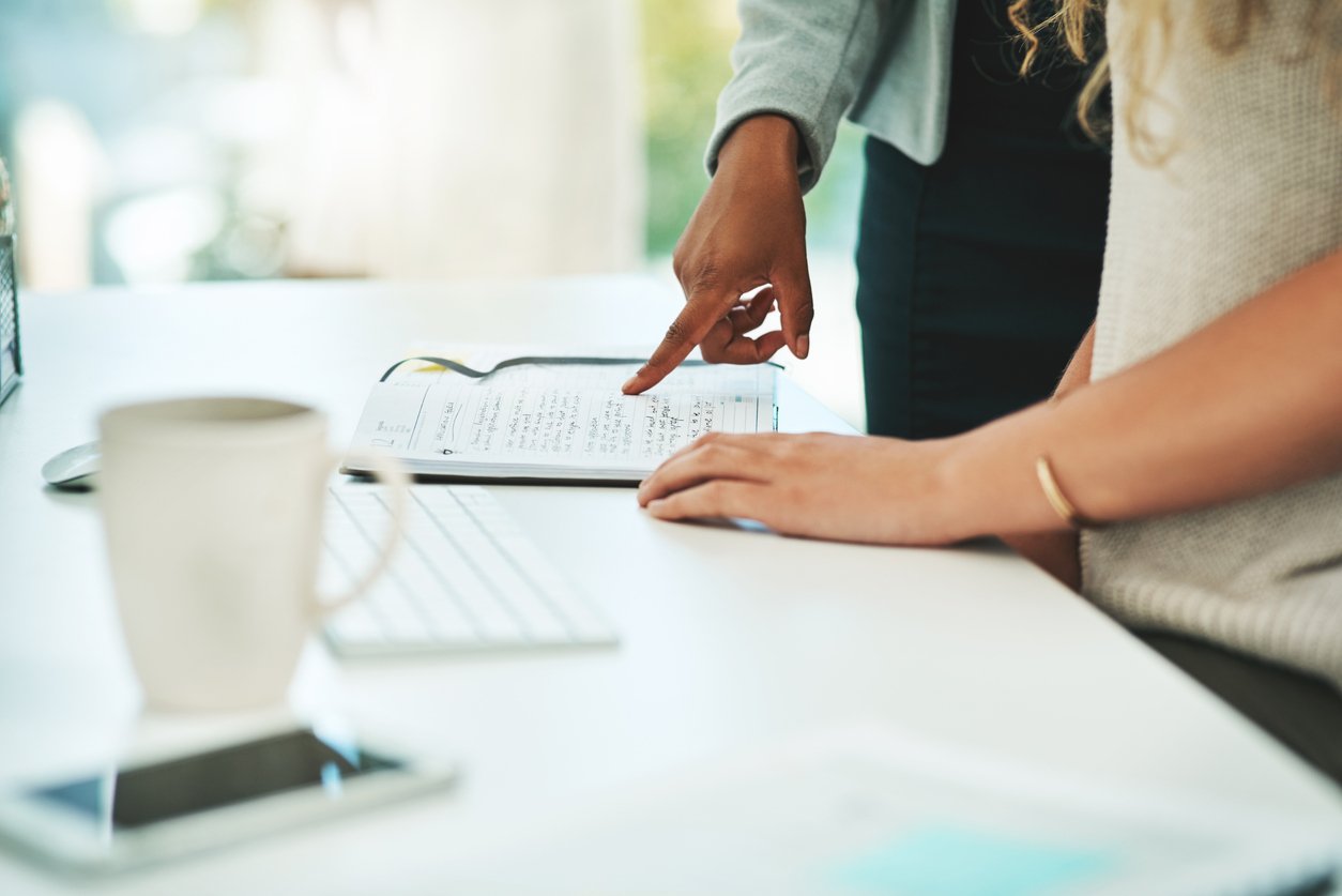 Client consultation with a personalized organizing plan being reviewed together at a desk.