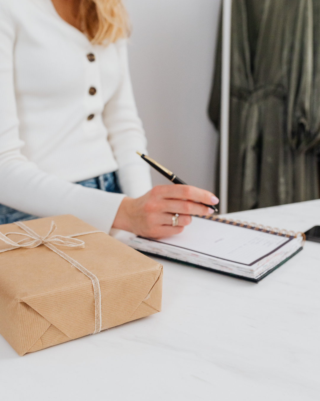 Woman using a planner at a tidy kitchen island while creating simple home organization systems.