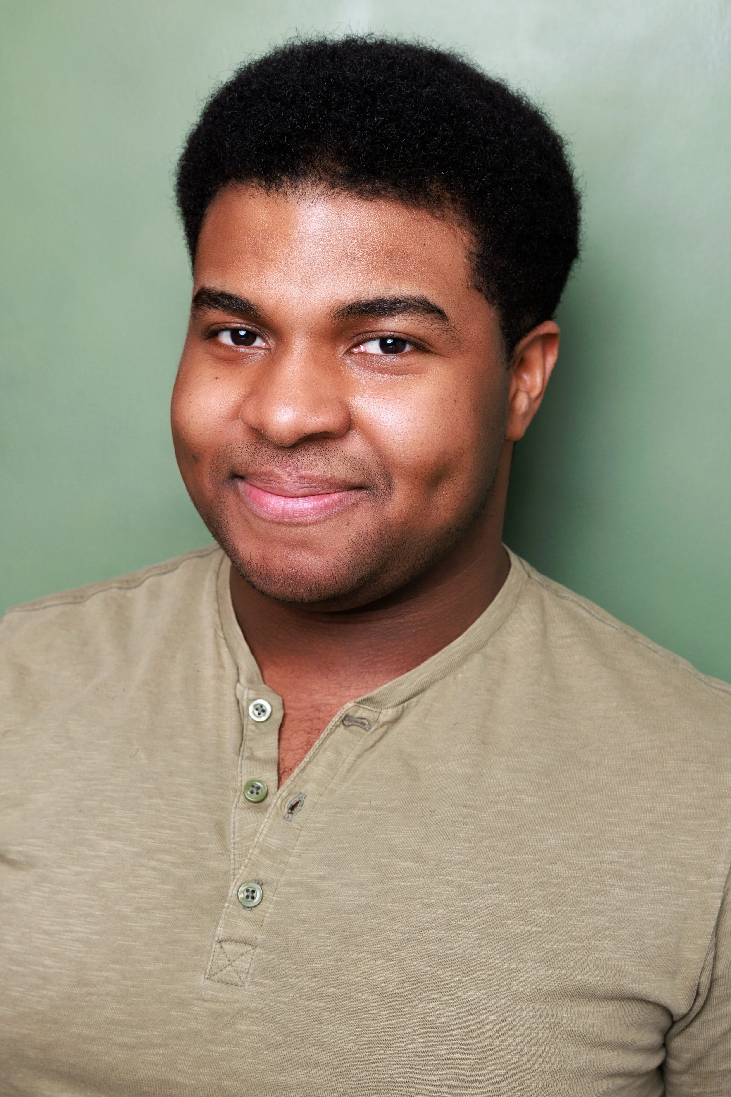 Close-up headshot of a young man, Steven Rutledge, with short curly black hair, wearing a green shirt, standing against a green background.

Taken by Robert Quiles (@robertredphoto on IG)