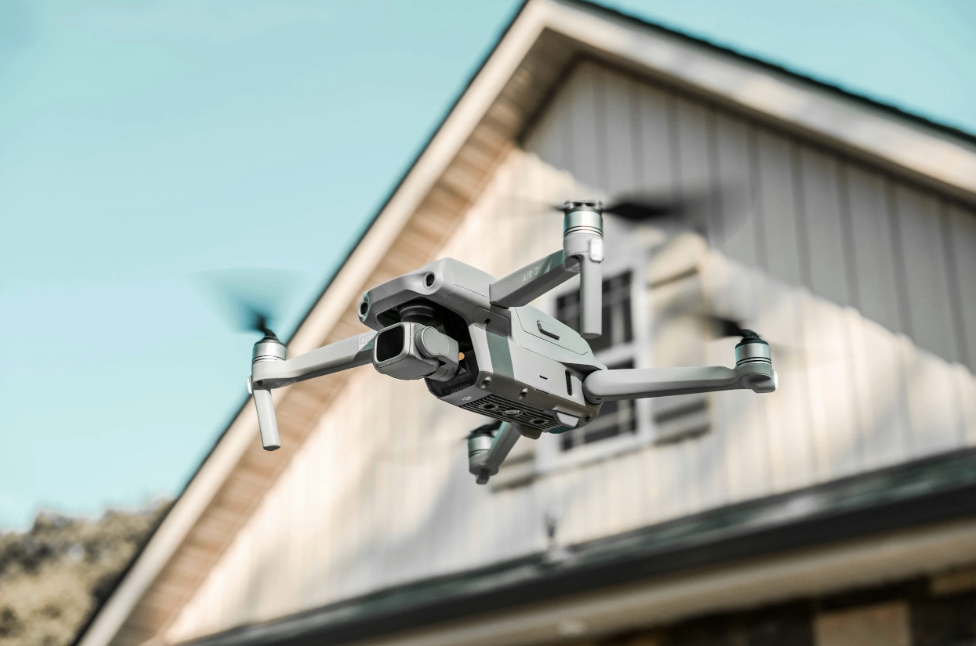 Airborne drone flying in front of a house