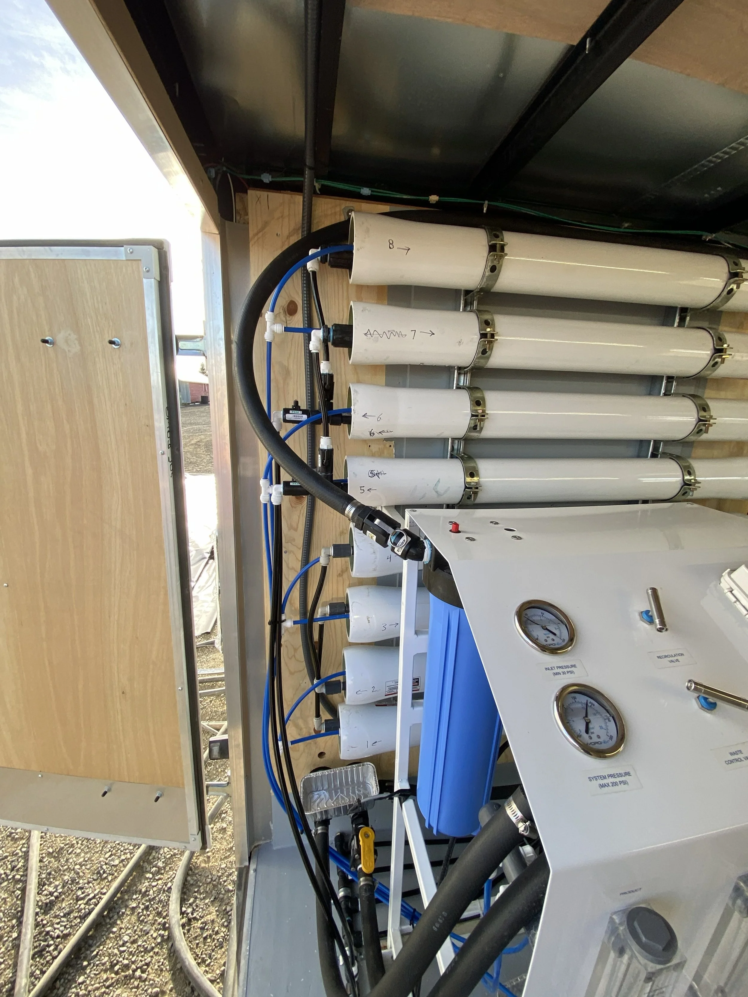 Close up of the Pursanova water system filters built into a mobile trailer