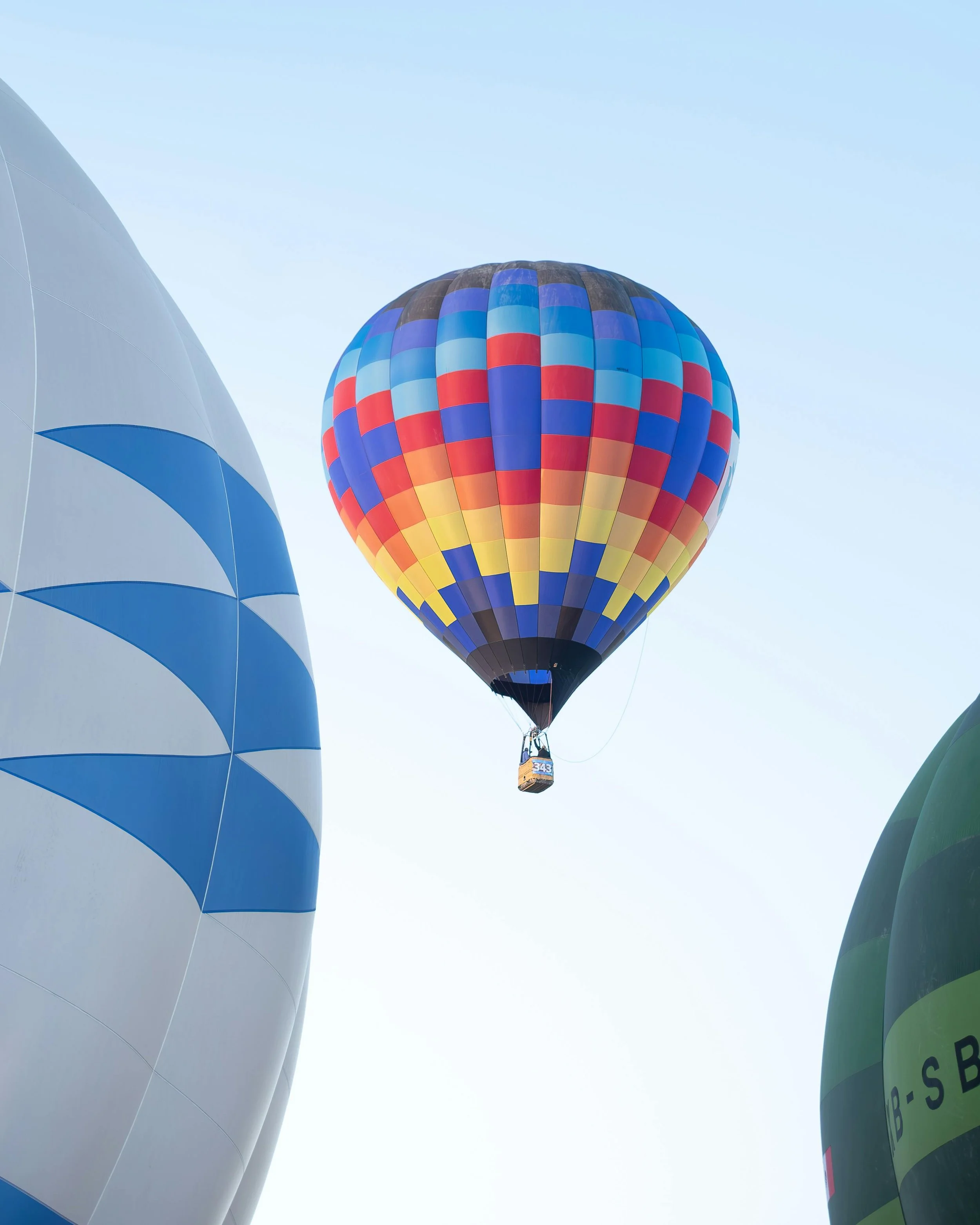 Colorful hot air balloons floating in the sky, with a blue sky background.