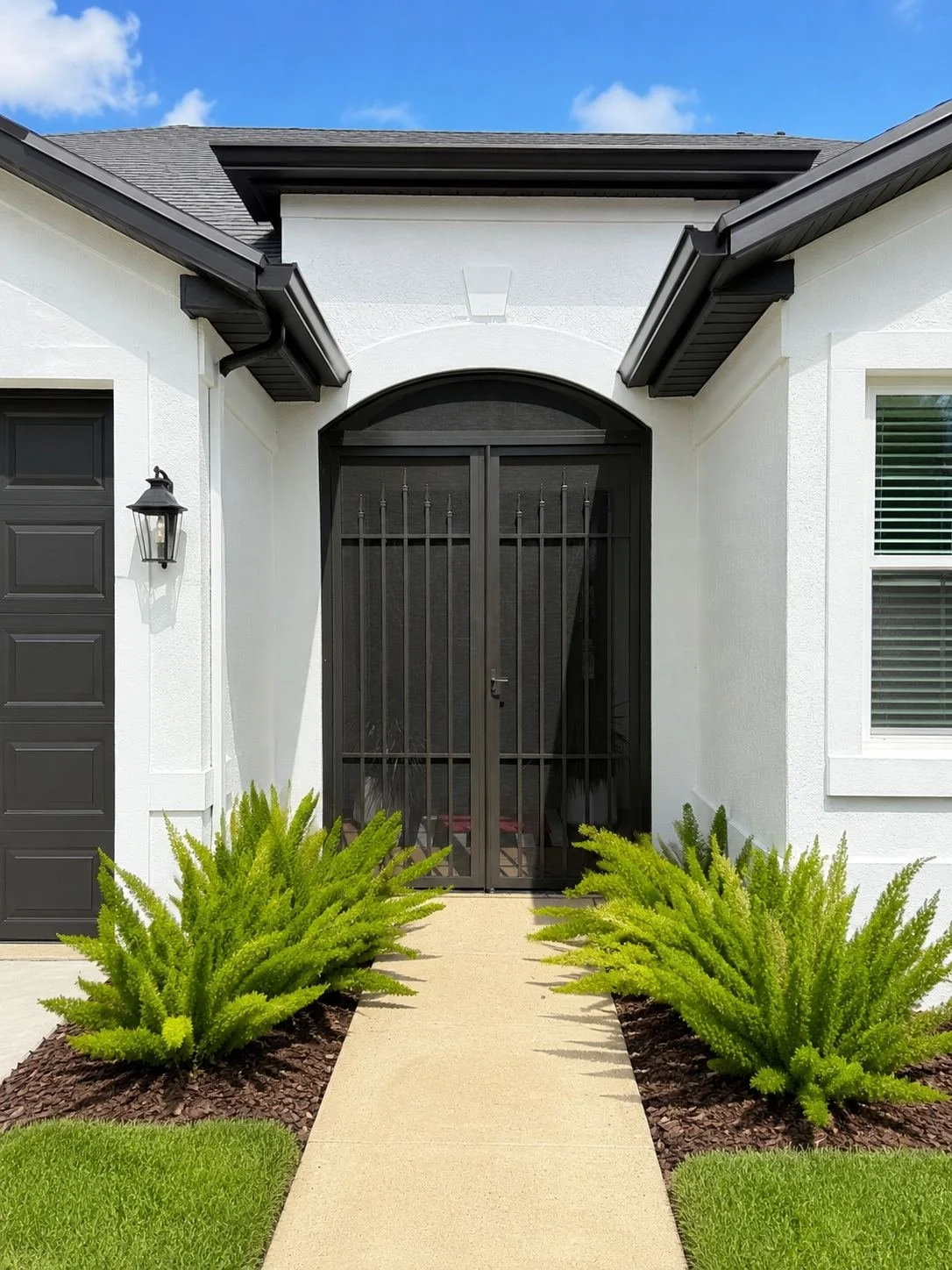 Modern house entrance with lush landscaping.jpg