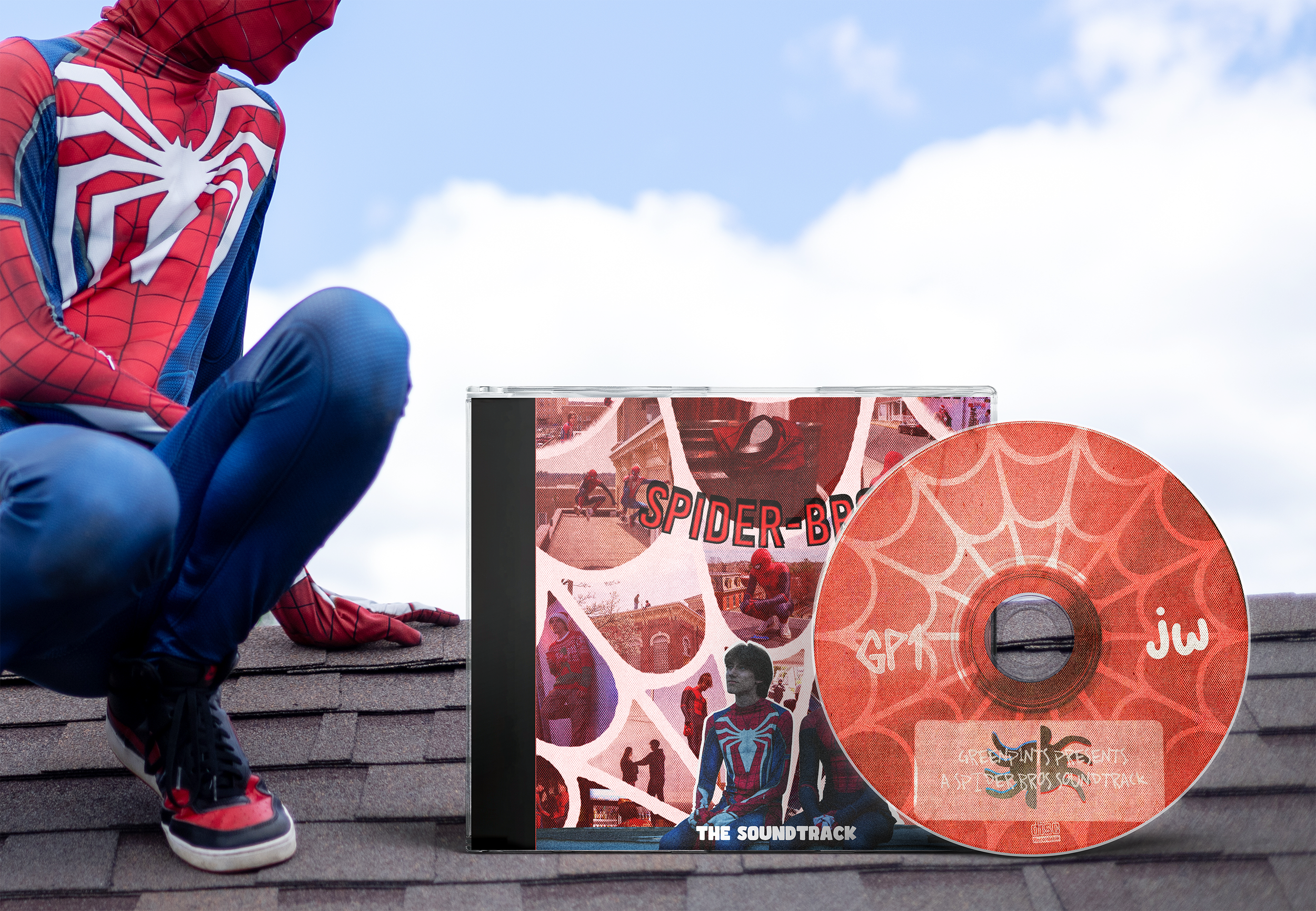 A person dressed as Spider-Man sitting on a roof next to a Spider-Man themed soundtrack CD and its case, with a partly cloudy sky in the background.