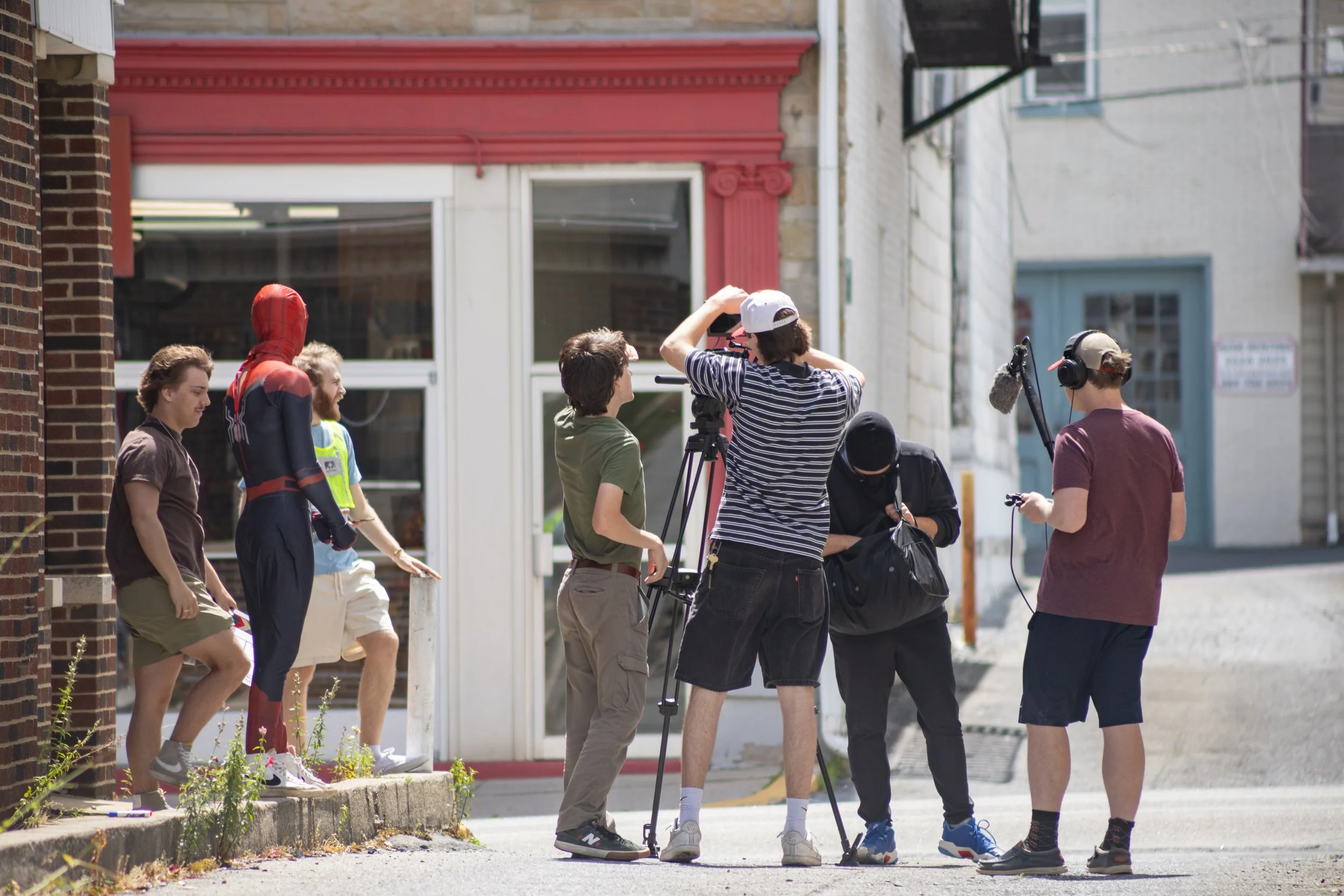 A film crew filming a scene outdoors on a city street with people watching