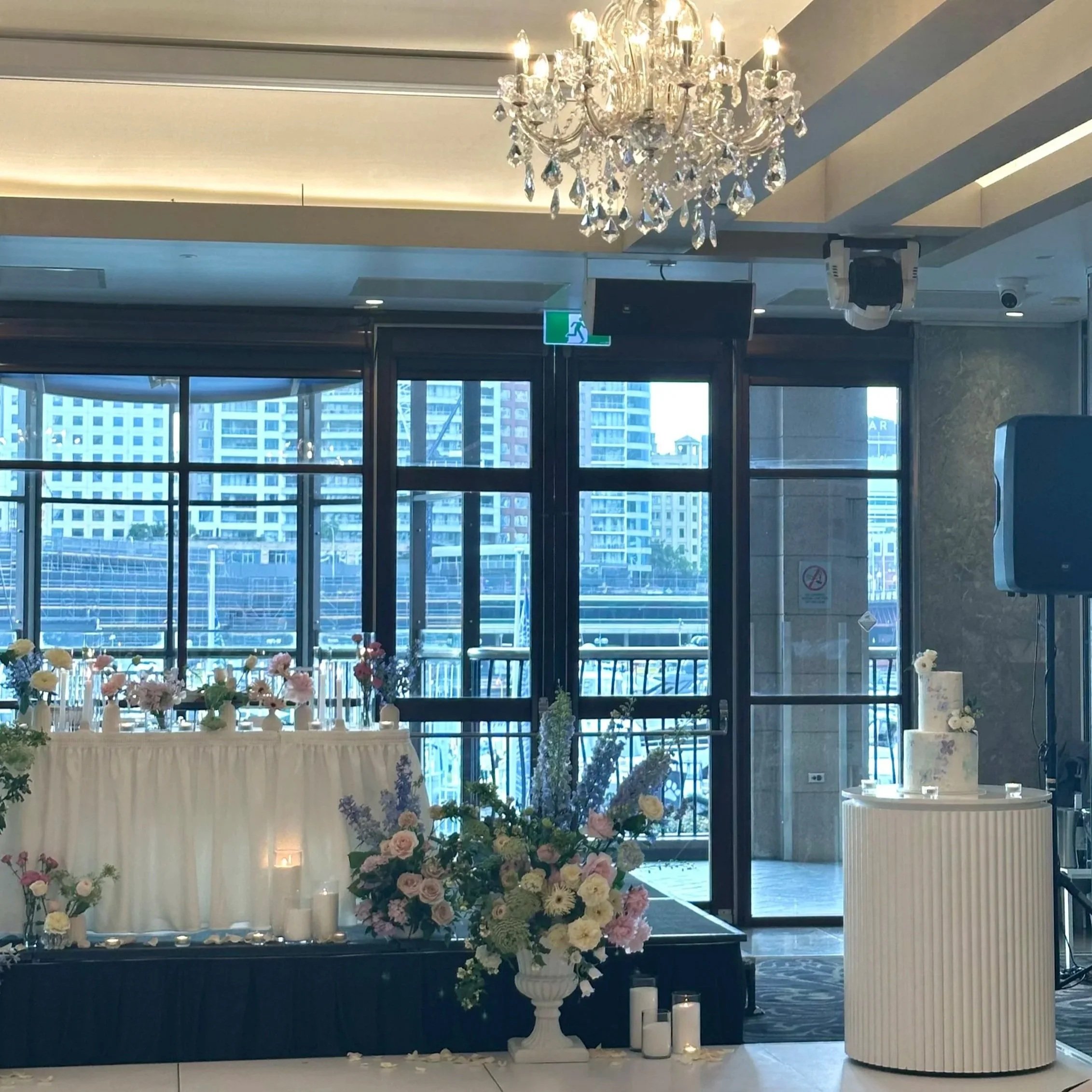 Modern wedding reception setup with floral arrangements and cake display in a Sydney venue.