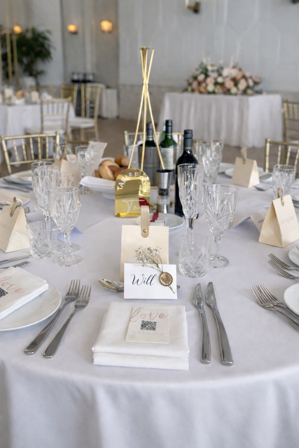 Elegant Sydney wedding reception tablescape with gold table numbers, layered glassware and neutral styling