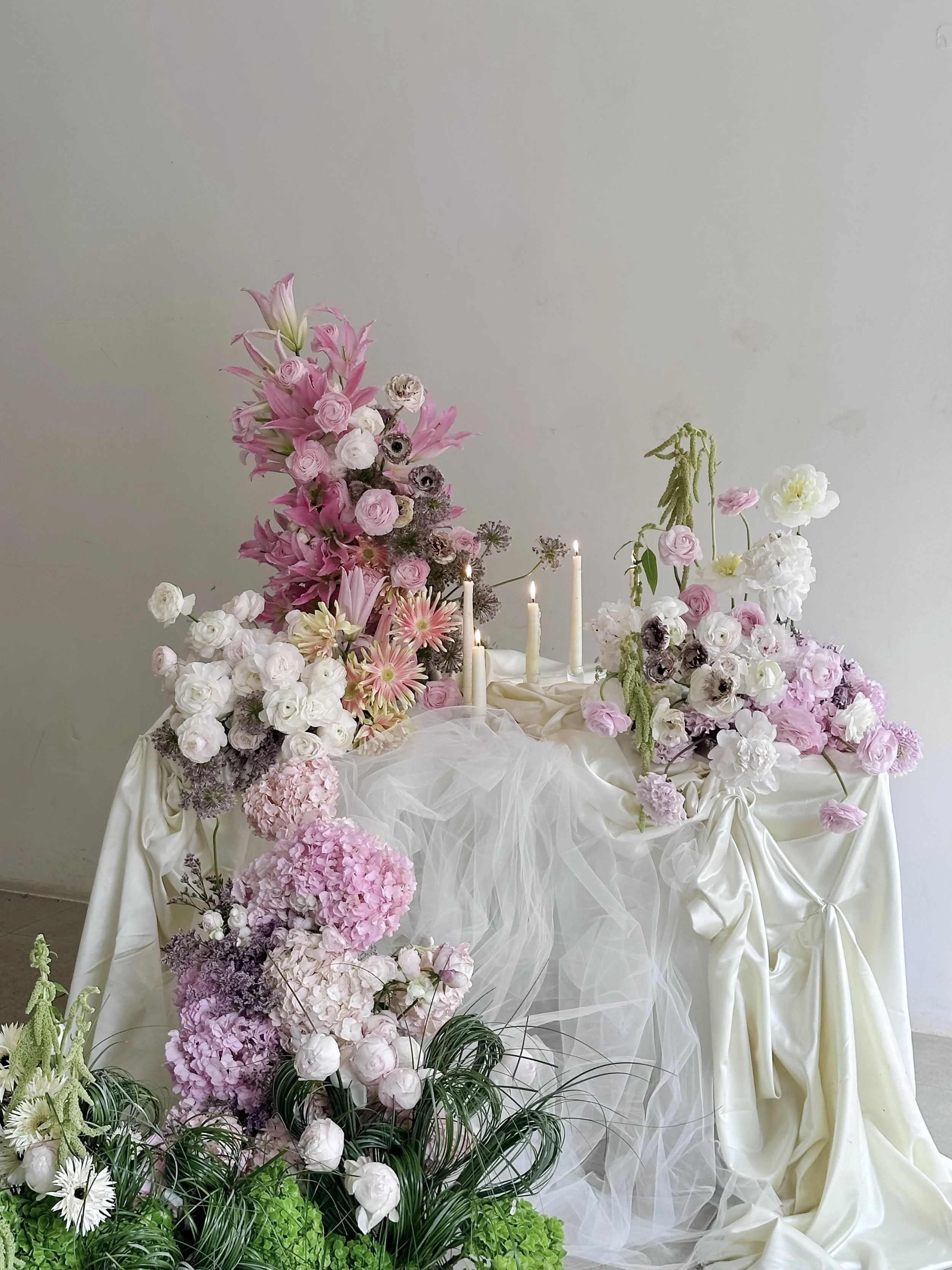 Editorial floral installation featuring romantic pink blooms, draped textiles, and sculptural floral design.