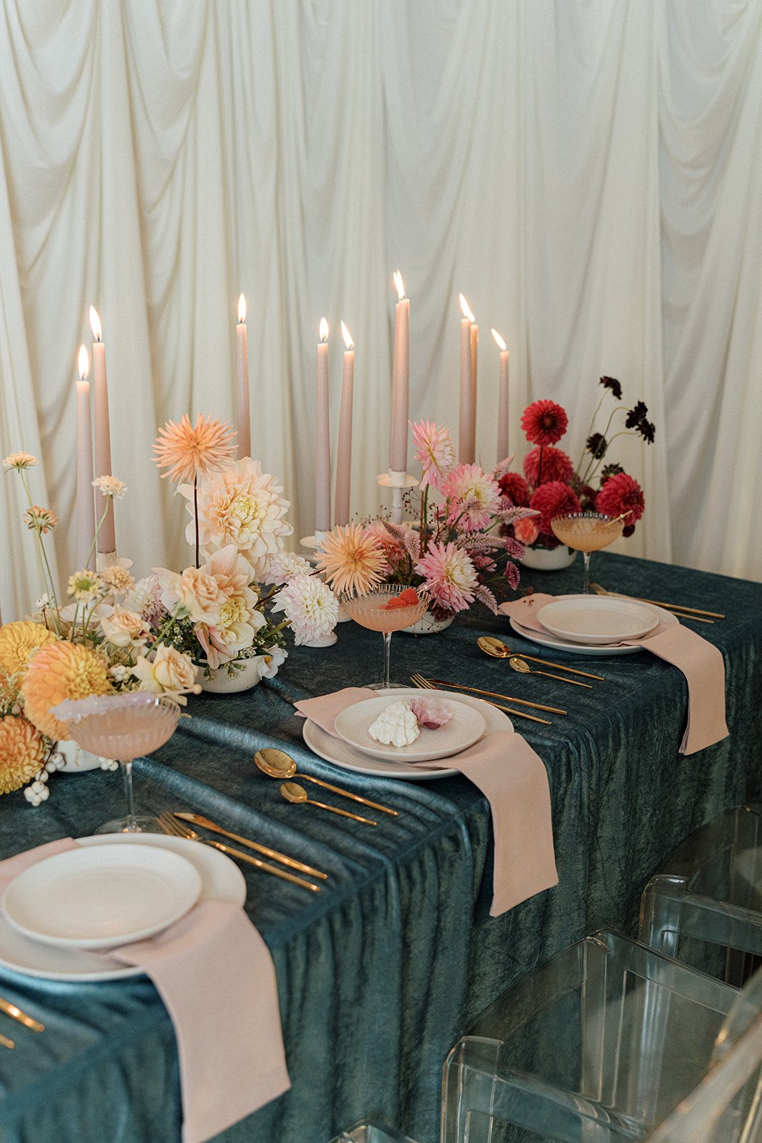 Editorial wedding tablescape detail with peach and cream dahlias, textural flowers, candlelight, and a raspberry cocktail. Floral design by Butterfly’s Rest. Photography by Amy Law Photography.