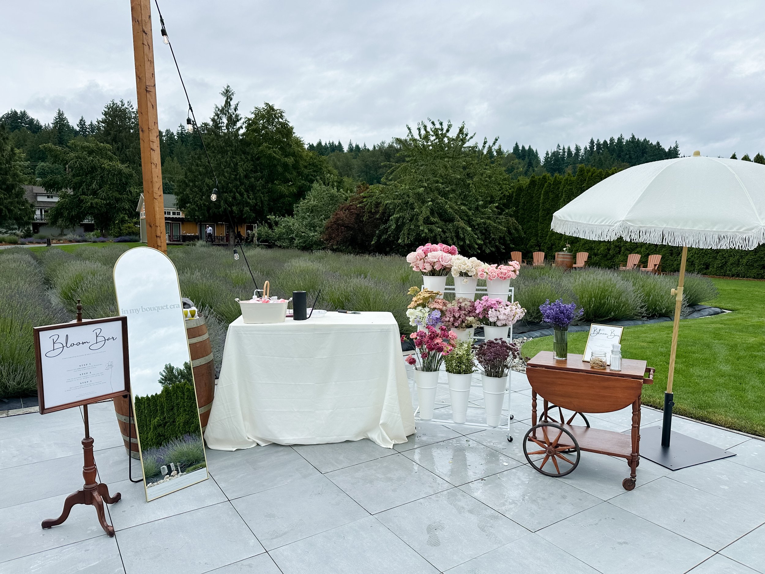 Bloom Bar floral experience featuring fresh flowers, bouquet-building stations, and guest participation at an outdoor event.