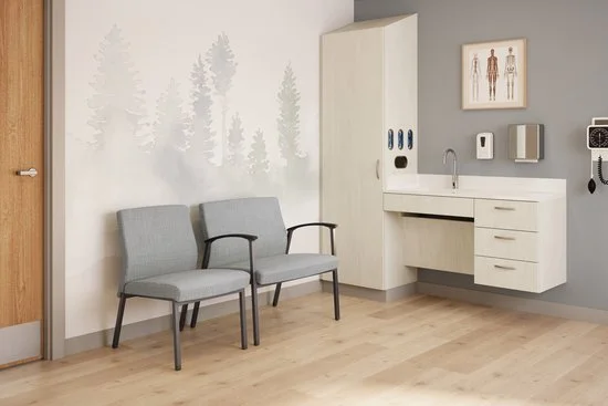 Waiting room with two gray chairs, a wooden door, and medical cabinets on the wall.