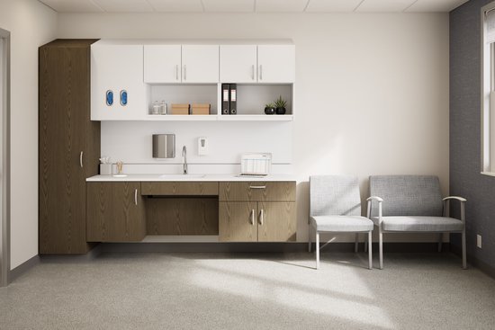 Hospital recovery room with white cabinets, wooden lower cabinets, a sink, and two gray chairs.