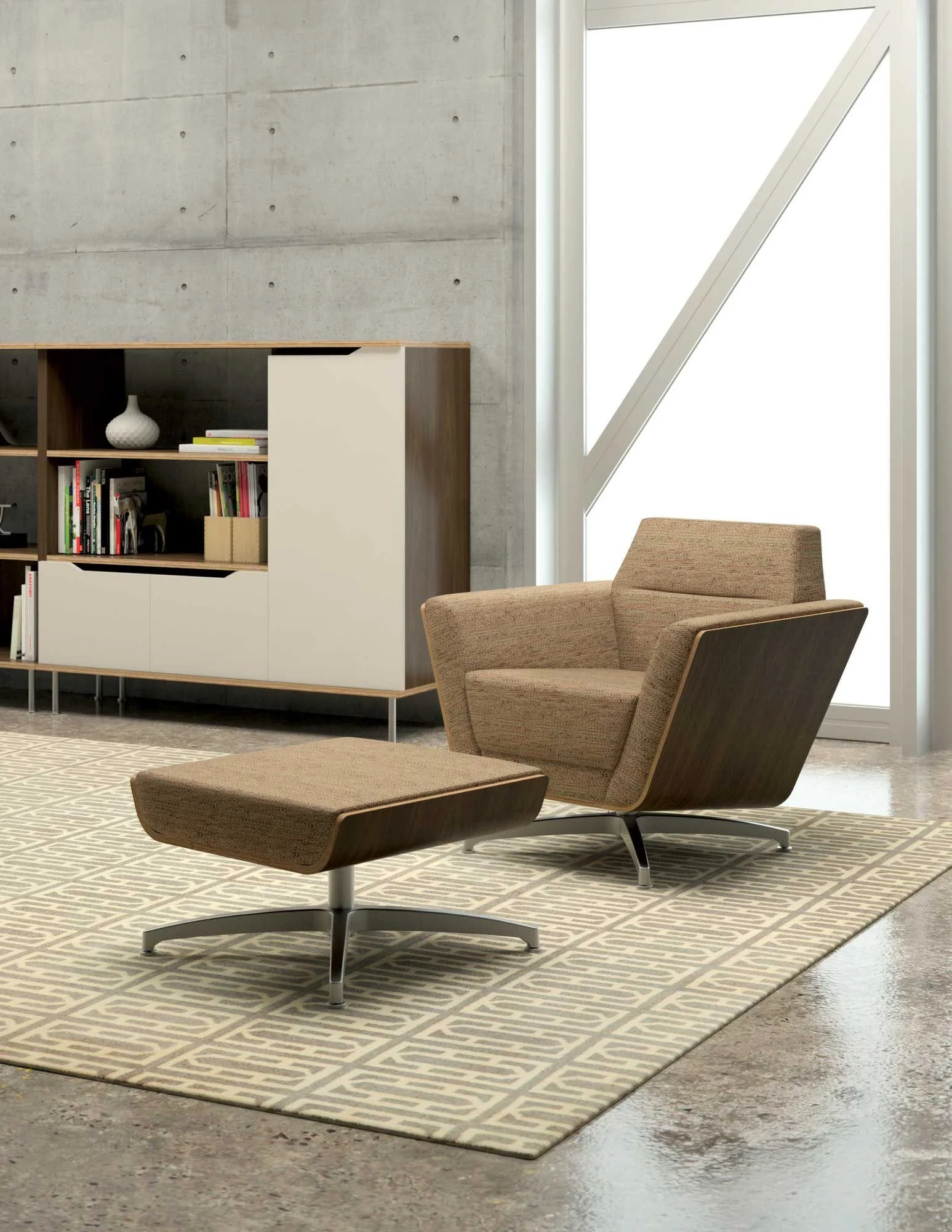 Modern living room with a tan armchair and matching ottoman, a patterned rug, and a built-in bookshelf against a concrete wall near large windows.