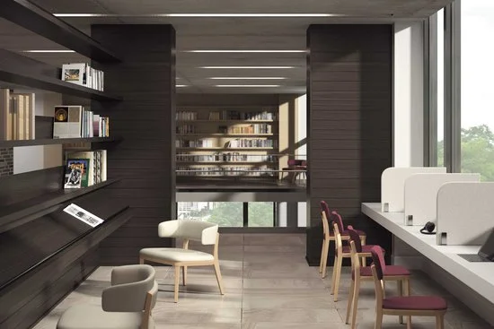 Interior of a modern library with bookshelves, seating area, and individual study booths near large windows.
