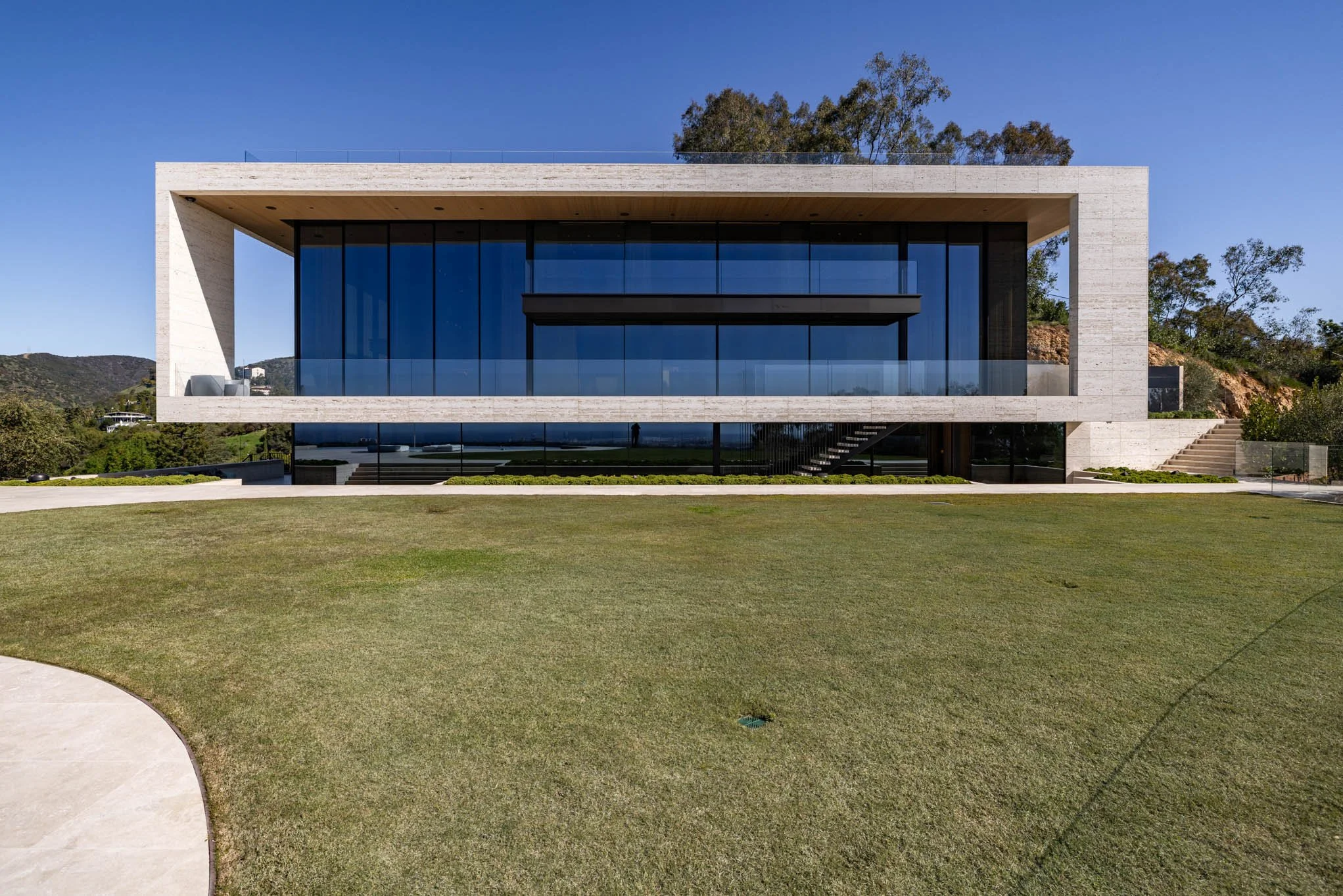 Modern house with large glass windows and open lawn in front